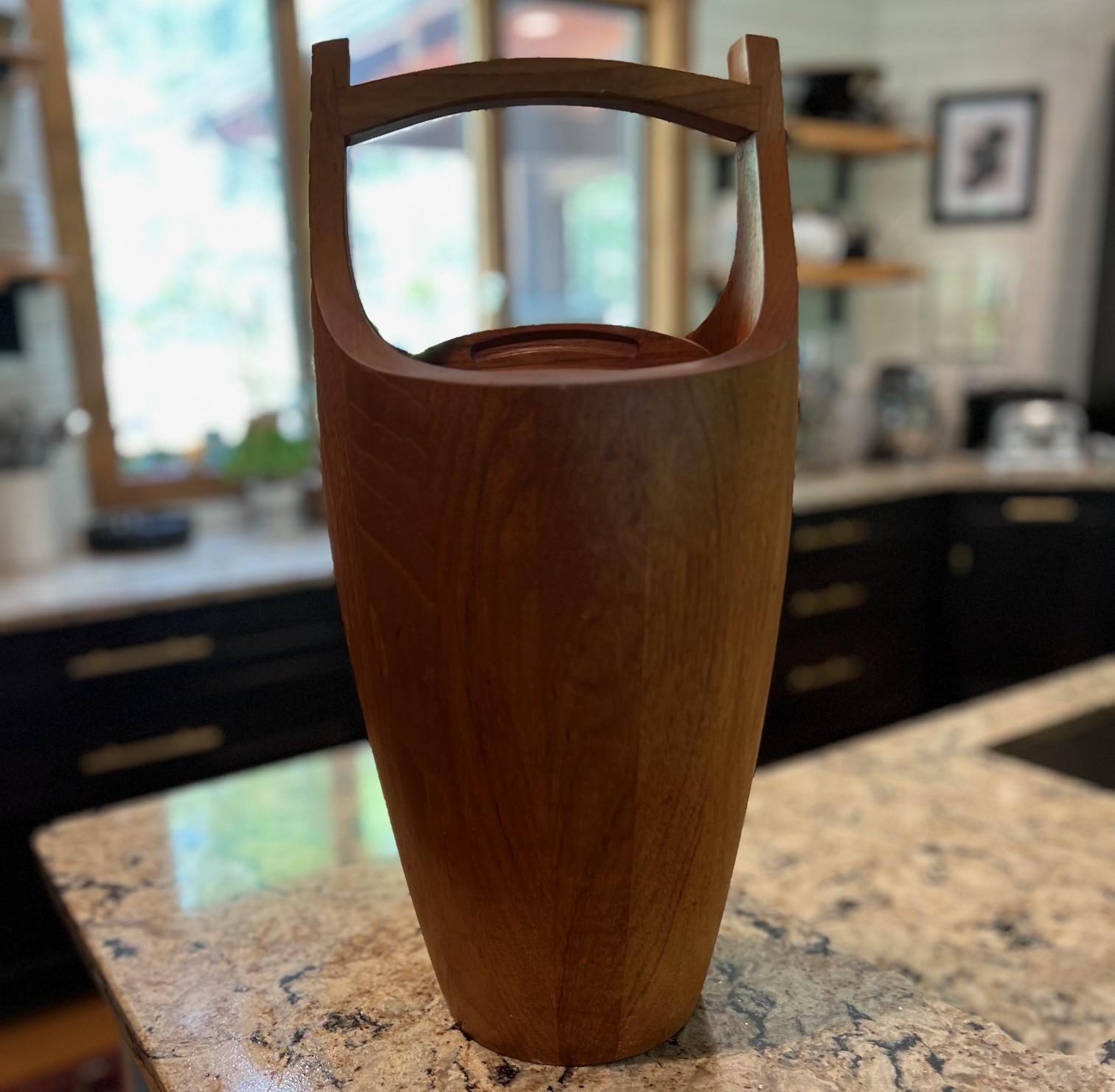 Secchiello per il ghiaccio grande in teak di MCM Jens Quistgaard per Dansk con coperchio e manico girevole

Descrizione:
Uno scultoreo secchiello per il ghiaccio in teak di stile danese moderno, disegnato da Jens Quistgaard per Dansk. Questo pezzo