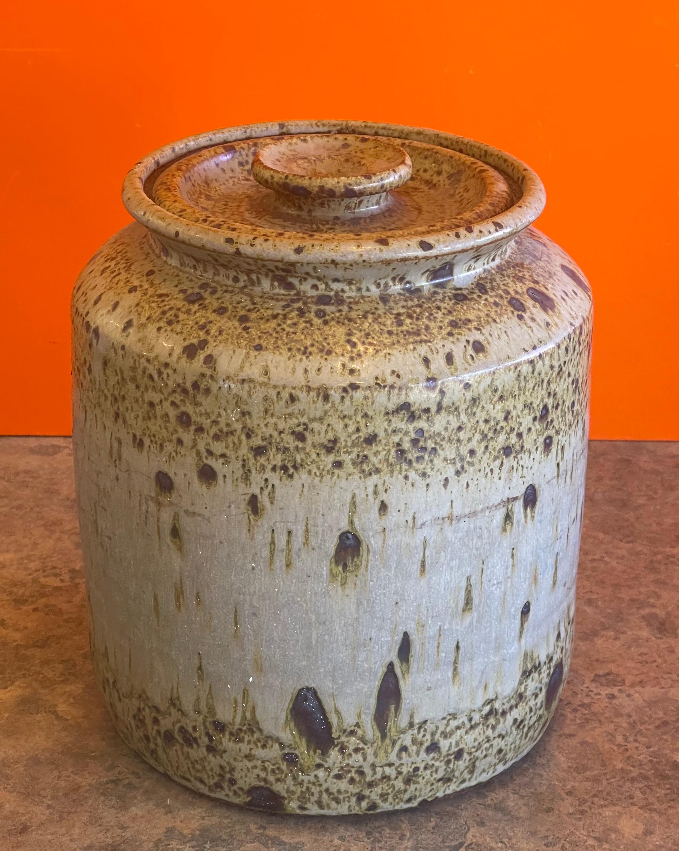 Large MCM stoneware studio pottery cookie jar with lid, circa 1970s. This gorgeous wheel thrown and hand finished jar has a wonderful design and great texture. The piece measures 9