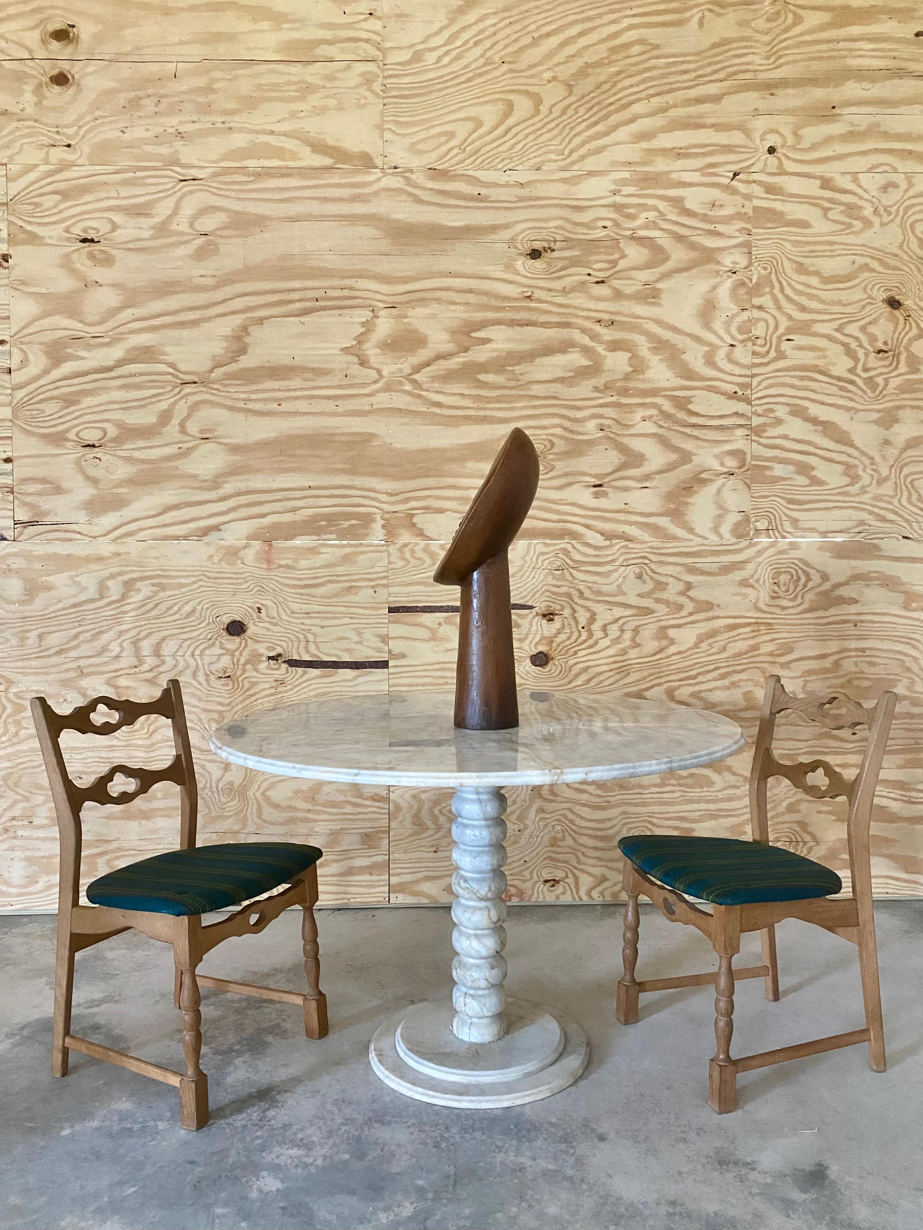 Presenza imponente e contemplativa, questa scultura monumentale in legno intagliato presenta una forma umana astratta con un'espressione morbida e serena. La lavorazione artigianale mette in mostra la bellezza naturale del legno, con curve dolci e