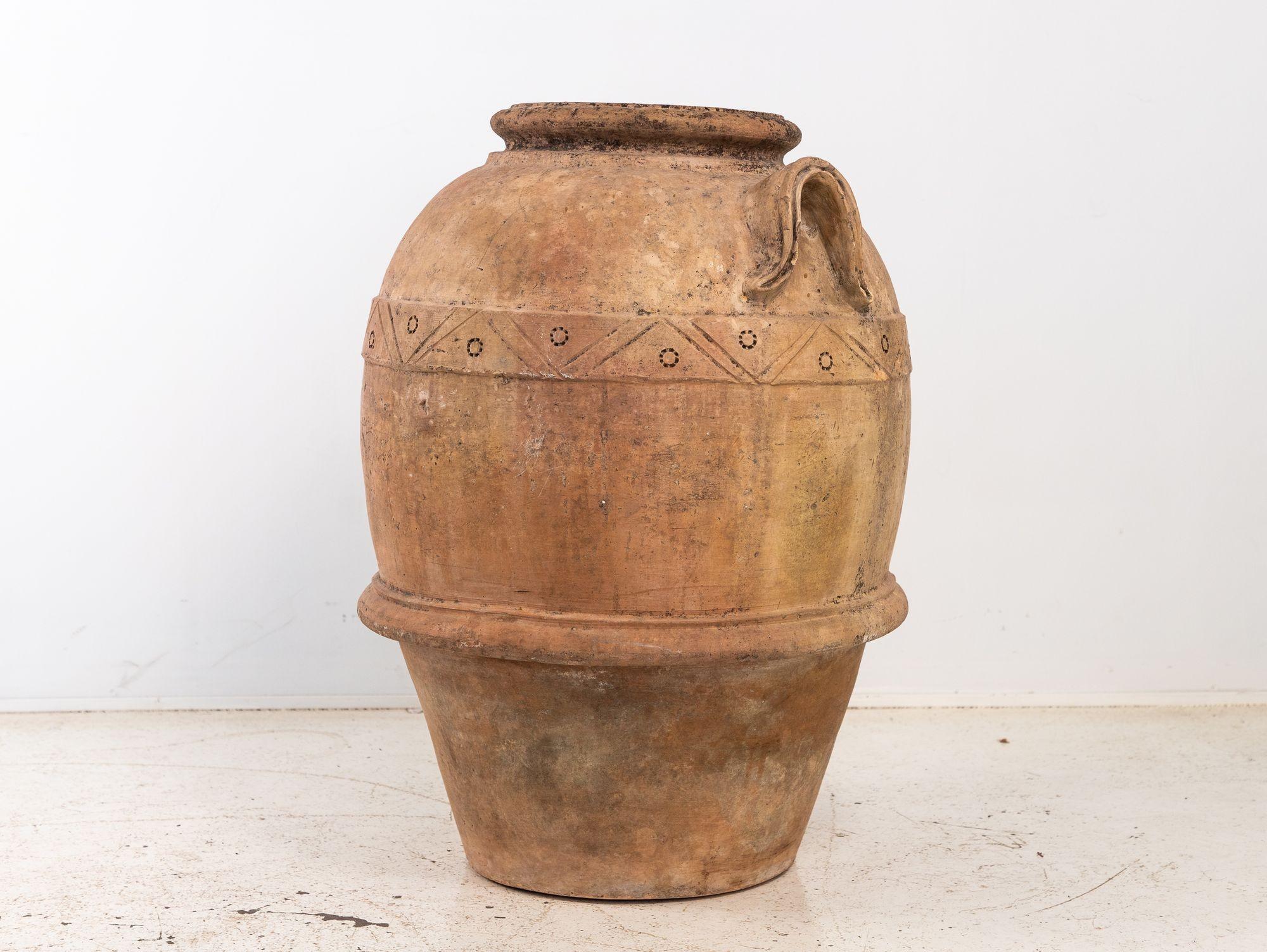 La grande jarre à olives méditerranéenne en terre cuite, différente d'un pot Biot, en est un exemple étonnant. Fabriqué avec soin par des artisans qualifiés, il met en valeur l'allure rustique de la poterie en terre cuite. De haute taille, sa teinte