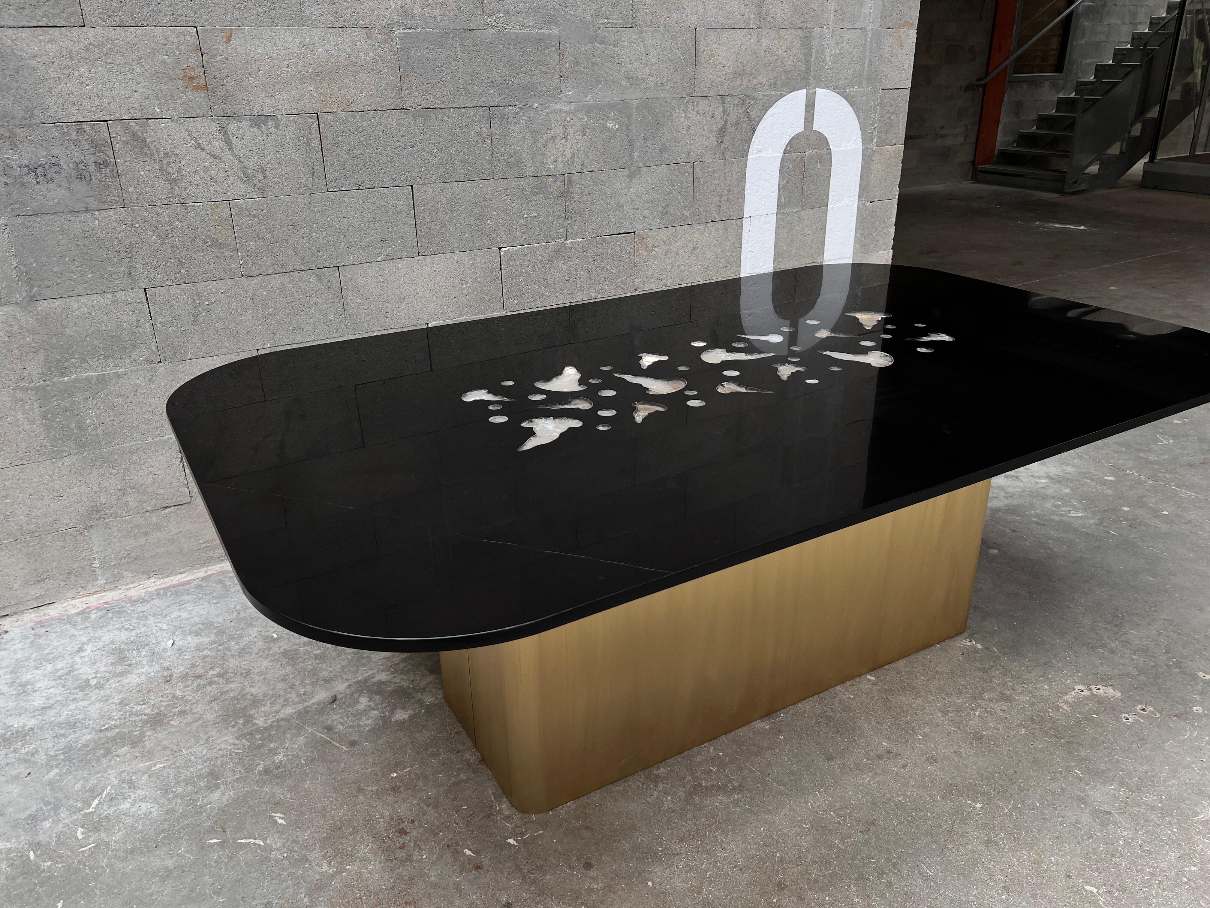 El tablero de esta gran mesa de comedor es de fino mármol belga negro con estilizadas inclusiones en forma de medusa de cristal de roca de Madagascar. La transparencia y riqueza del cristal de roca se ve realzada por una tira de LED de 24 V