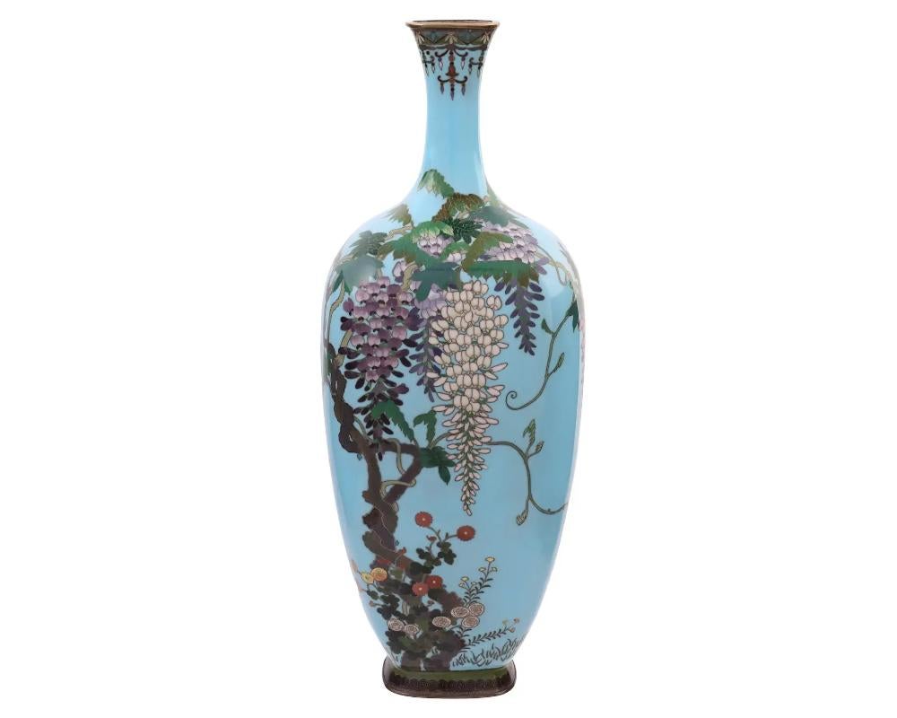 A high quality Japanese, Meiji era, enamel and silver wire vase. The vase has an amphora shaped body and a narrow neck. The ware is enameled with a polychrome image of blossoming flowers, plants, and trees made in the Cloisonne technique on