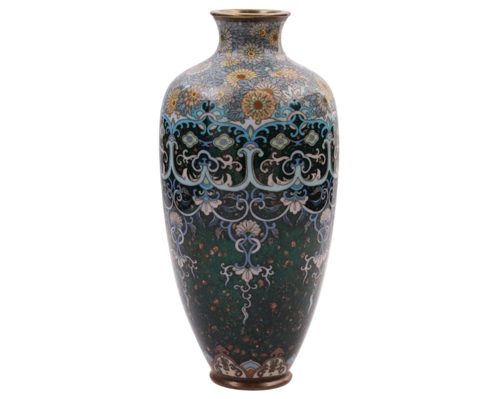 An antique Japanese copper vase with polychrome cloisonne enamel decor. Late Meiji period, before 1912. Elongated baluster shape. Intricate floral pattern against the dark green background. Gold stone flakes. High quality. Collectible Oriental Asian