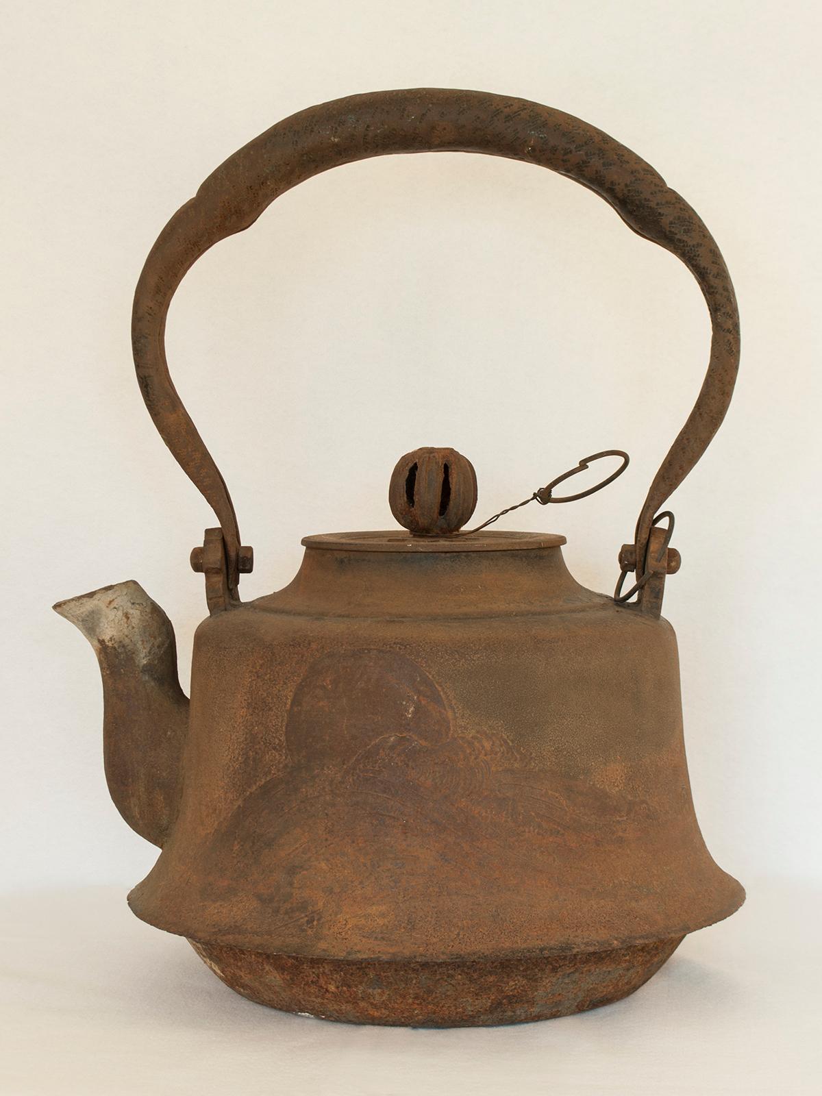 Large Meiji Period Iron Tea Pot, Japan

This very large iron tea pot would have been used outdoors to heat water over a large fire. There is a flying crane depicted on one side and a celestial body, perhaps the moon, setting in a wave-filled sea on