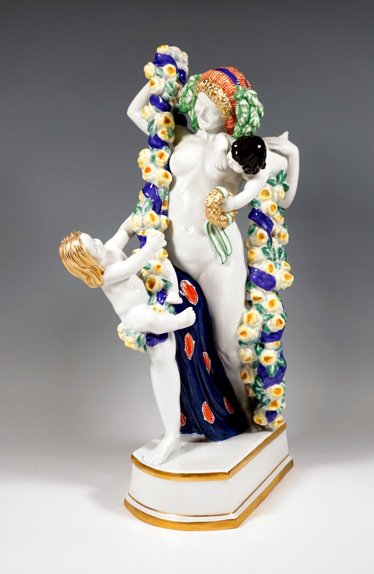 Extremely rare Art Nouveau Figurine Group by Meissen:
Monumental figure of Flora, taking a step forward in dance and holding large, heavy flower garlands of yellow roses, which are wrapped with a blue bow, in hands. The hair of the female nude is