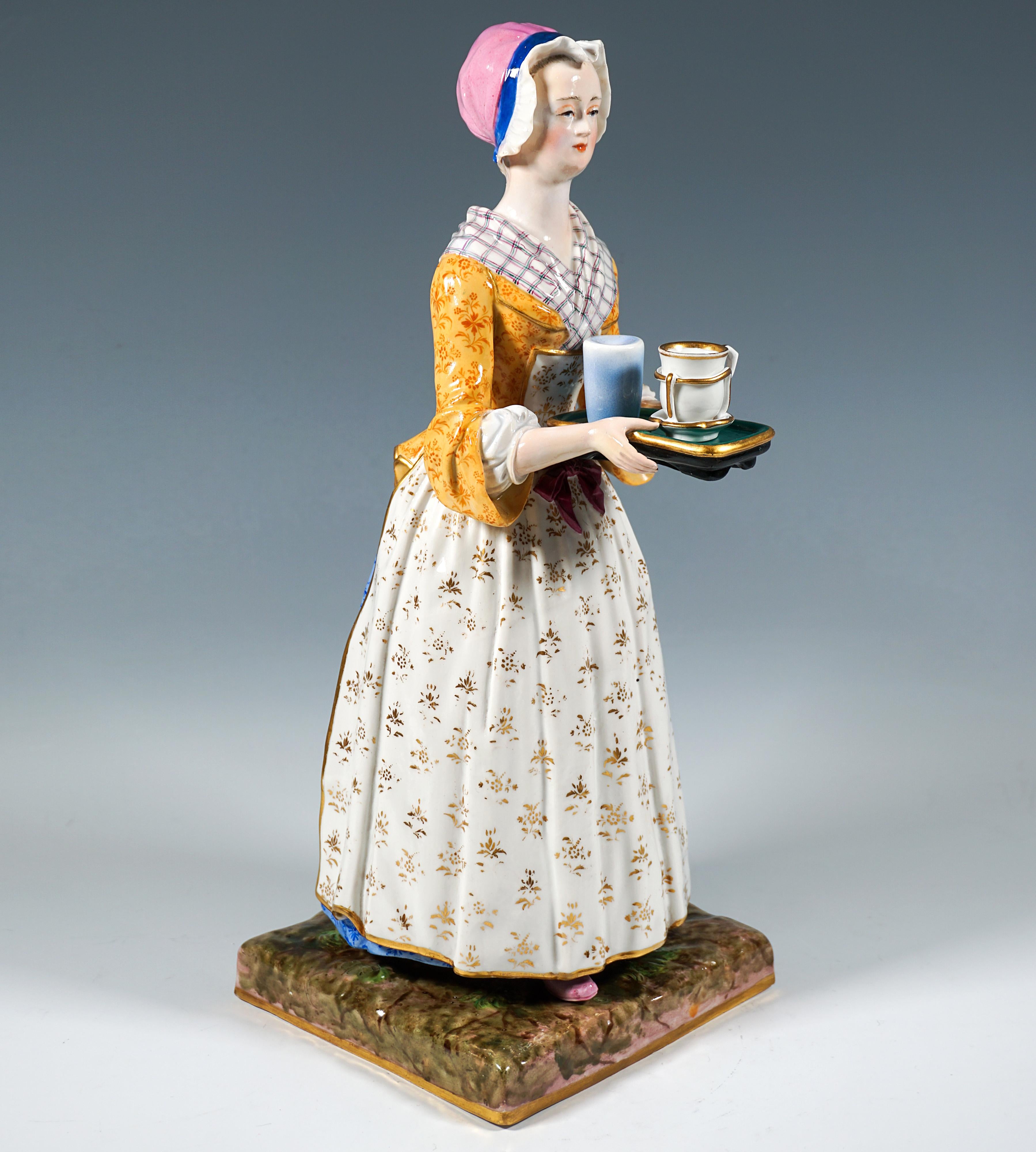 A young woman in the elaborate dress of a servant girl from the Rococo period with a stoically forward-facing gaze carrying an elongated tray with a chocolate cup and a glass of water with both hands at hip height in front of her.
The figure stands