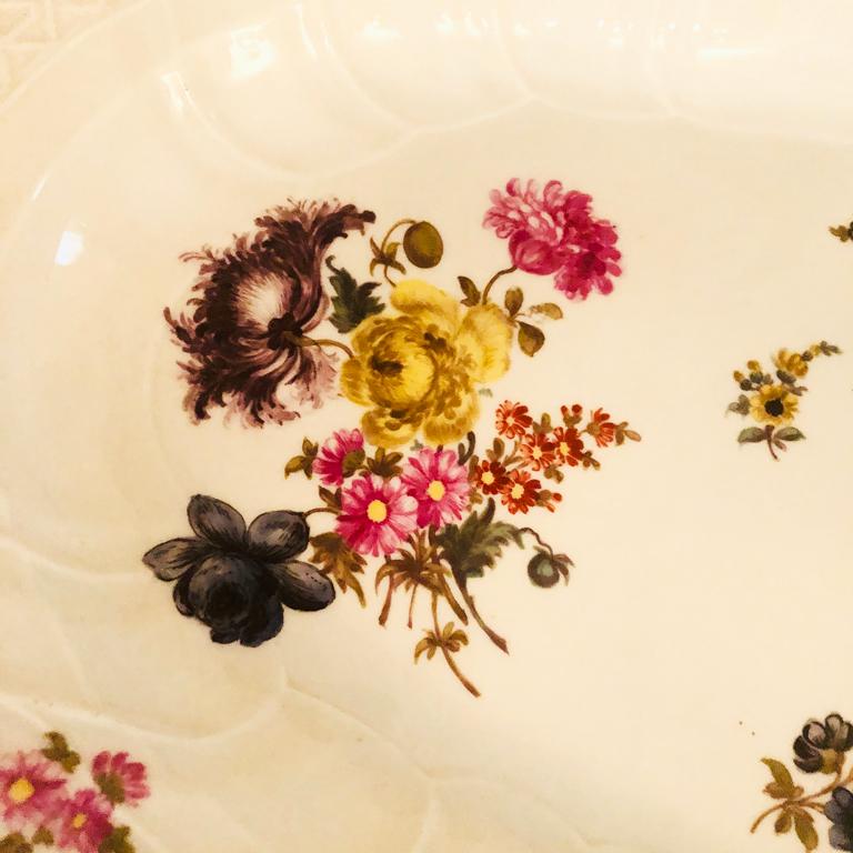 Large Meissen Platter with botanical paintings, fluted borders and curved pink edges on two sides. The botanical paintings are very well painted with spring and summer flower arrangements. On the large platter, you have room to serve both your