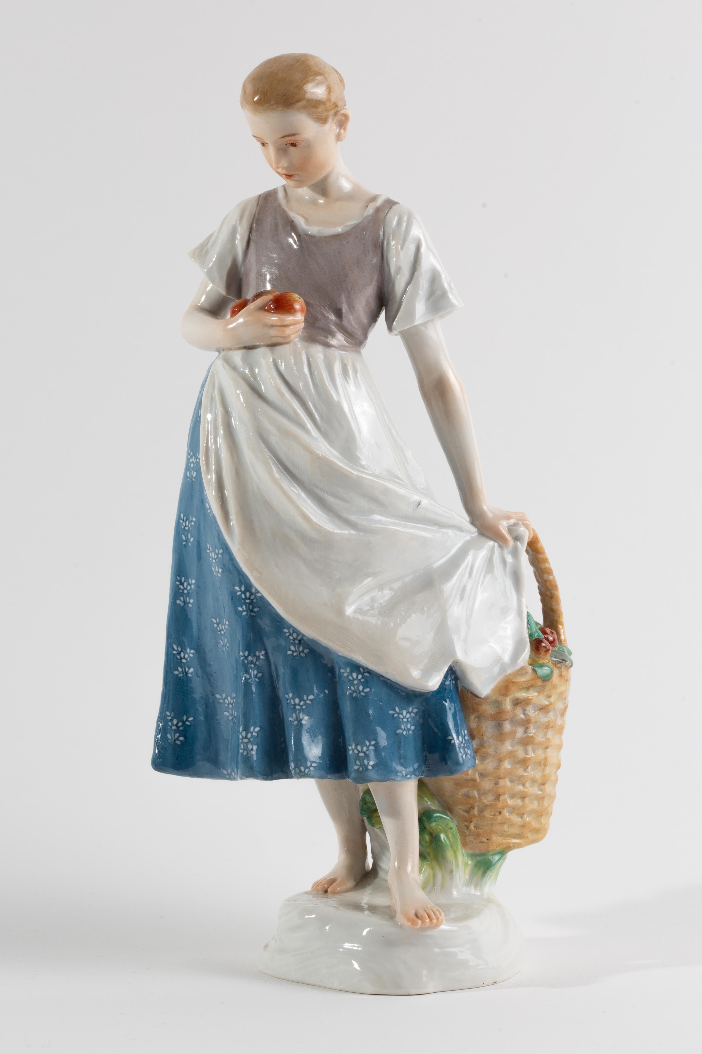 Meissener Porzellan Jugendstil Figur 'Mädchen mit Apfelkorb'

Die Porzellanfigur zeigt ein barfüßiges junges Mädchen, das neben einem mit Äpfeln gefüllten geflochtenen Korb steht. Sie ist so modelliert, dass sie mehrere Äpfel in ihrem linken Arm
