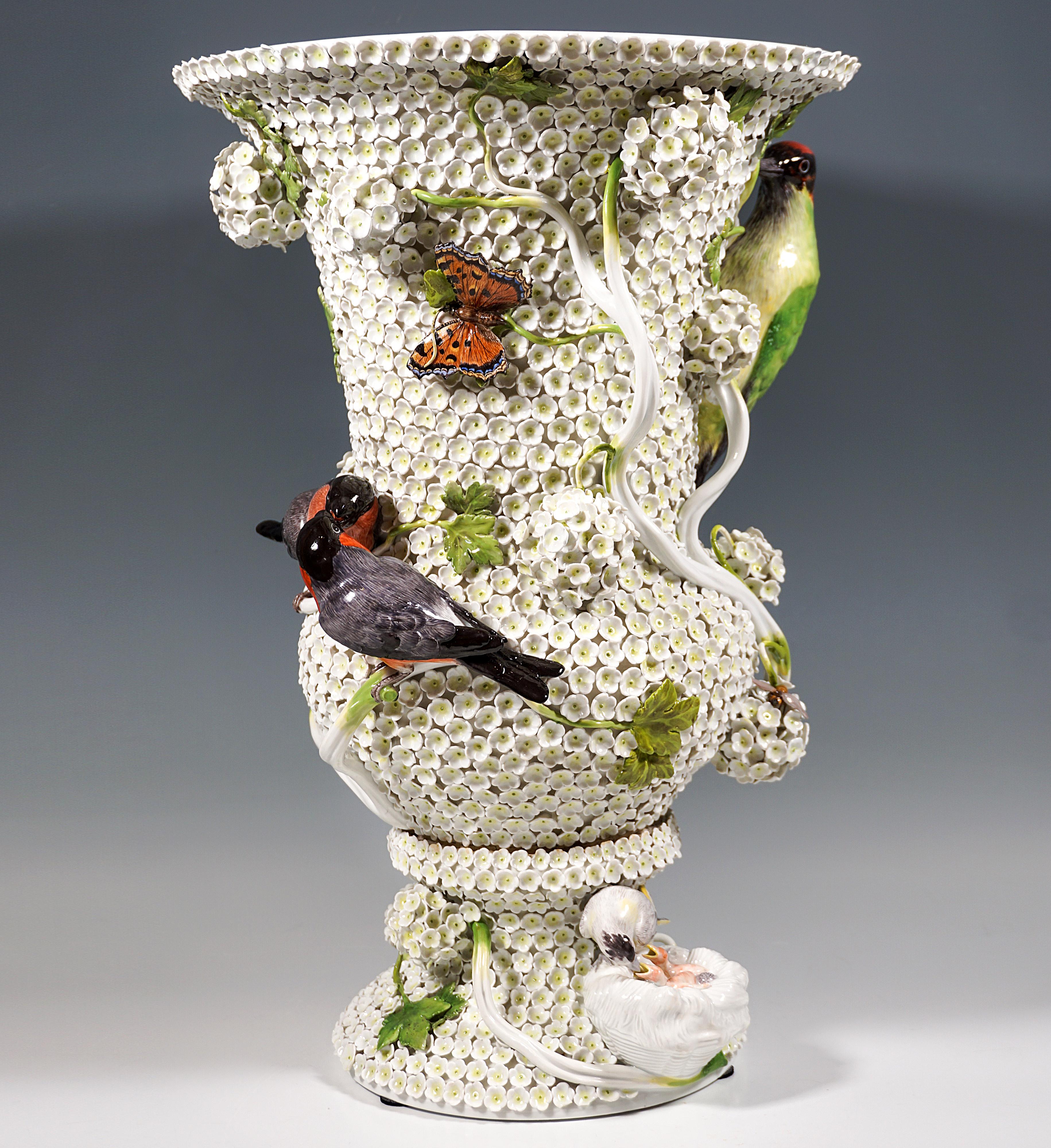 Large, very elaborately decorated crater vase from the Meissen manufactory, with abundant snowball blossoms on the outer wall, rising above the white flowers in fully sculpted tendrils with foliage, with a pair of birds billing on top, a woodpecker,