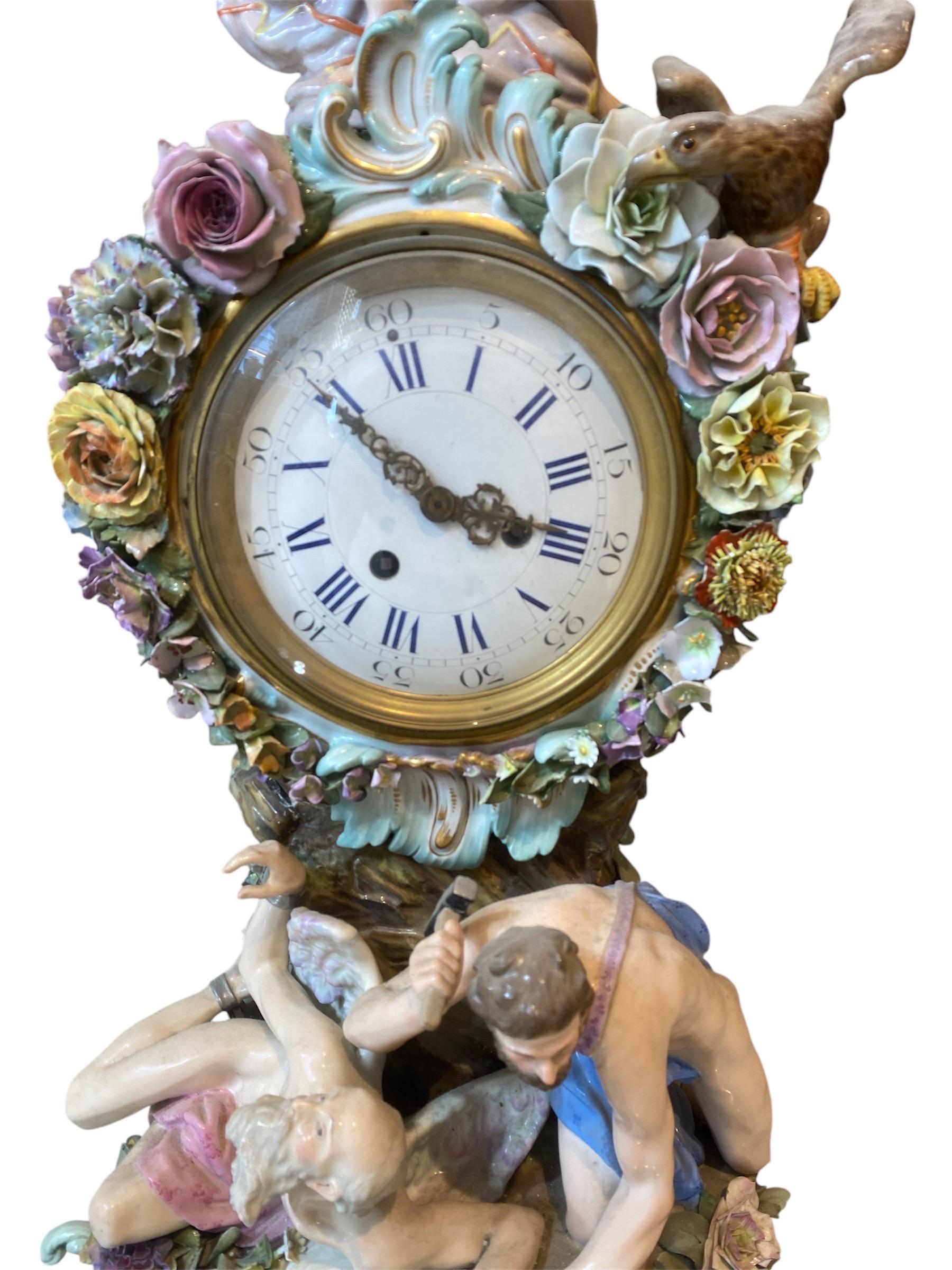 This magnificent Meissen clock rests on a rock pillar supported by five robust, gold-accented rocaille feet, richly adorned with intricately sculpted flowers, foliage, and elaborate rocaille motifs encircling the dial. At the pinnacle of the clock