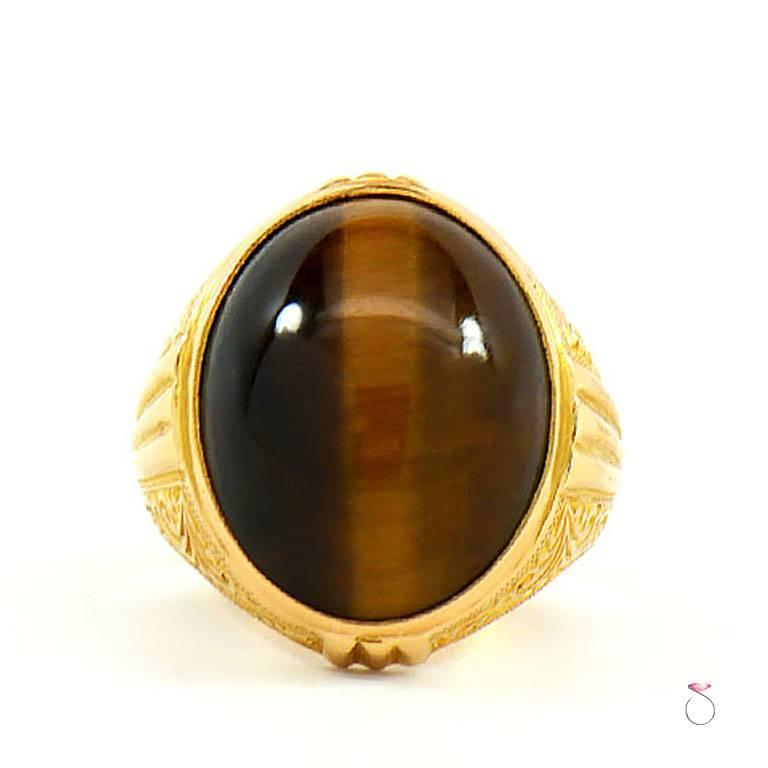 Men's large Tiger eye ring in 21k yellow gold. The beautiful High polished green oval cabochon Tiger eye has a beautiful natural color, that contrasts gracefully with the rich 21k yellow gold. The ring is very well crafted in 21k yellow golds with