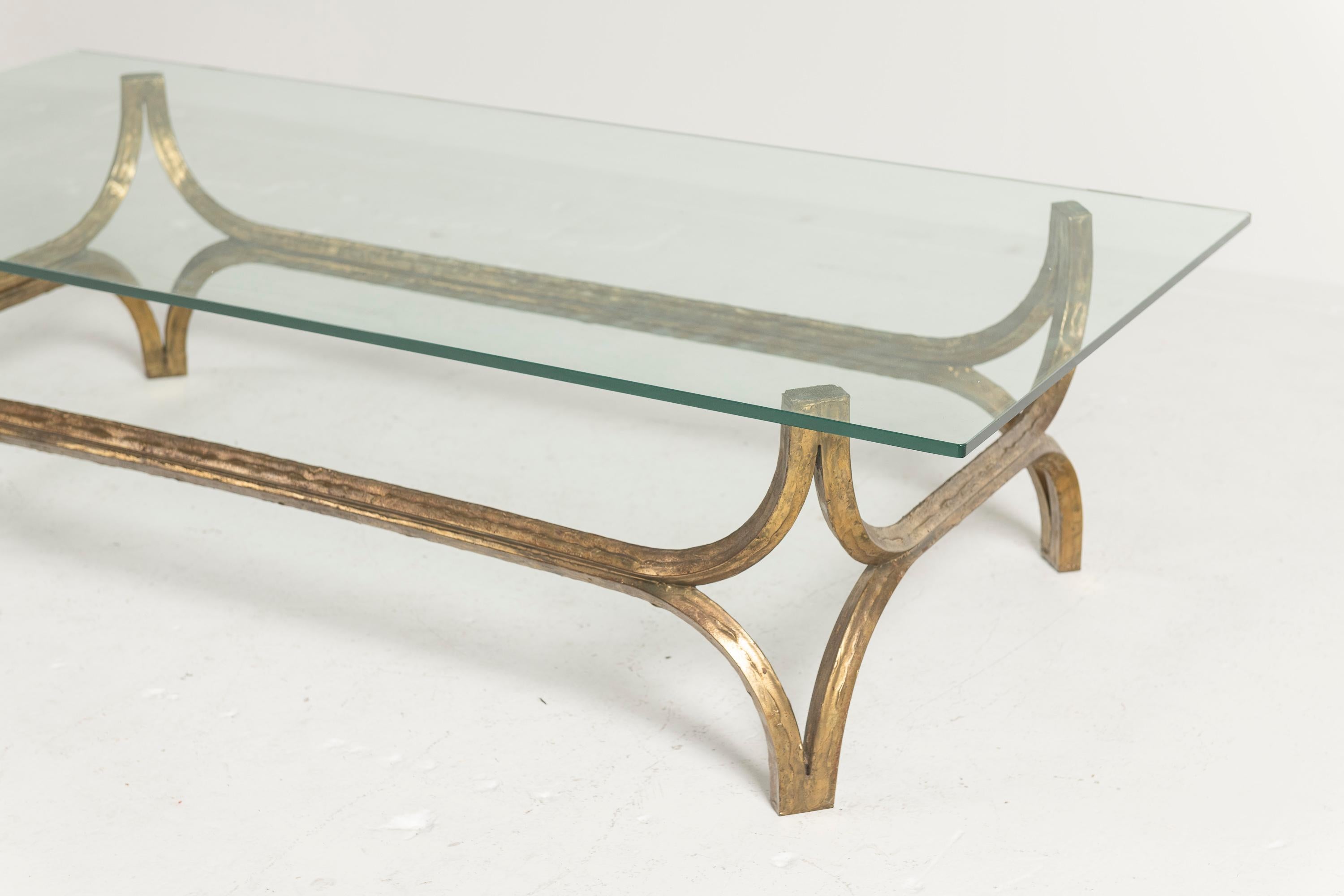 Des lignes simples, incurvées et sculptées créent le cadre de cette table basse en métal, qui se termine par un plateau rectangulaire en verre. De bonne taille pour un salon, une salle de séjour ou une salle familiale, cette pièce offre une bonne