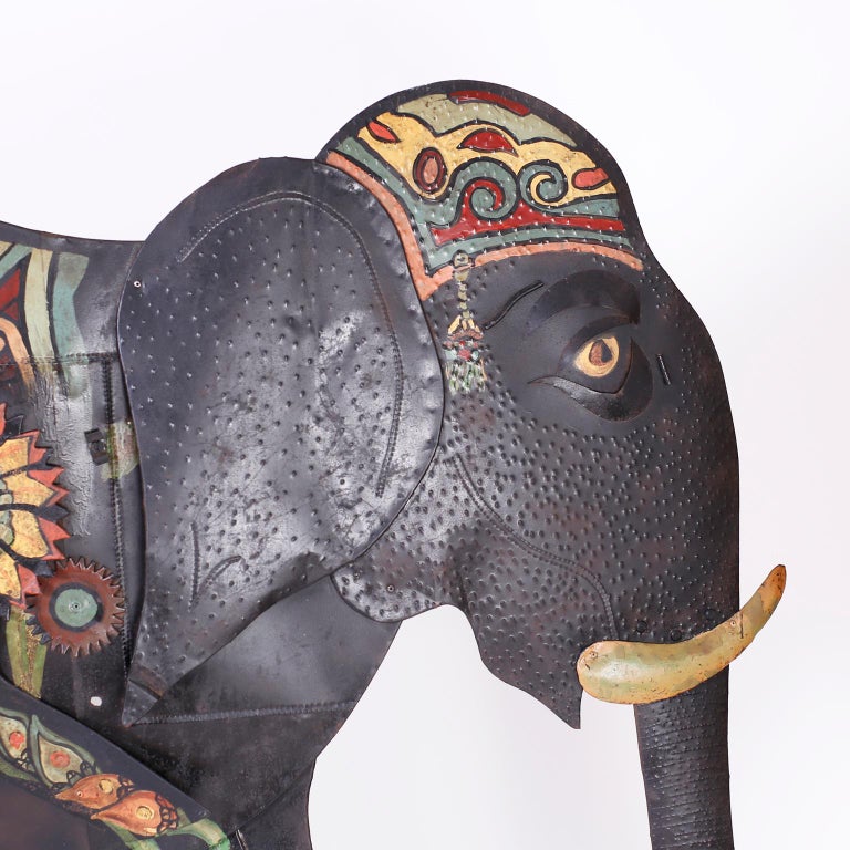 Bold one of a kind elephant wall sculpture hand crafted in metals with a stylized assemblage form decorated with paint in eccentric colorful floral designs.