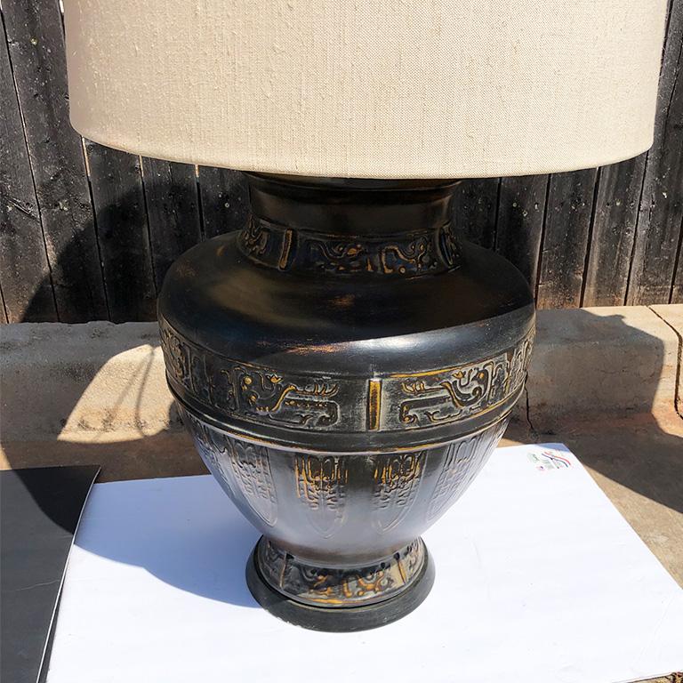 Large midcentury oversize metal lamp with original shade. The base is metal and in a gord shape. Top of base features beautifully intricate designs. Lamp comes with the original cloth shade with a band detail at the top. 

Measures: Shade: 24.25