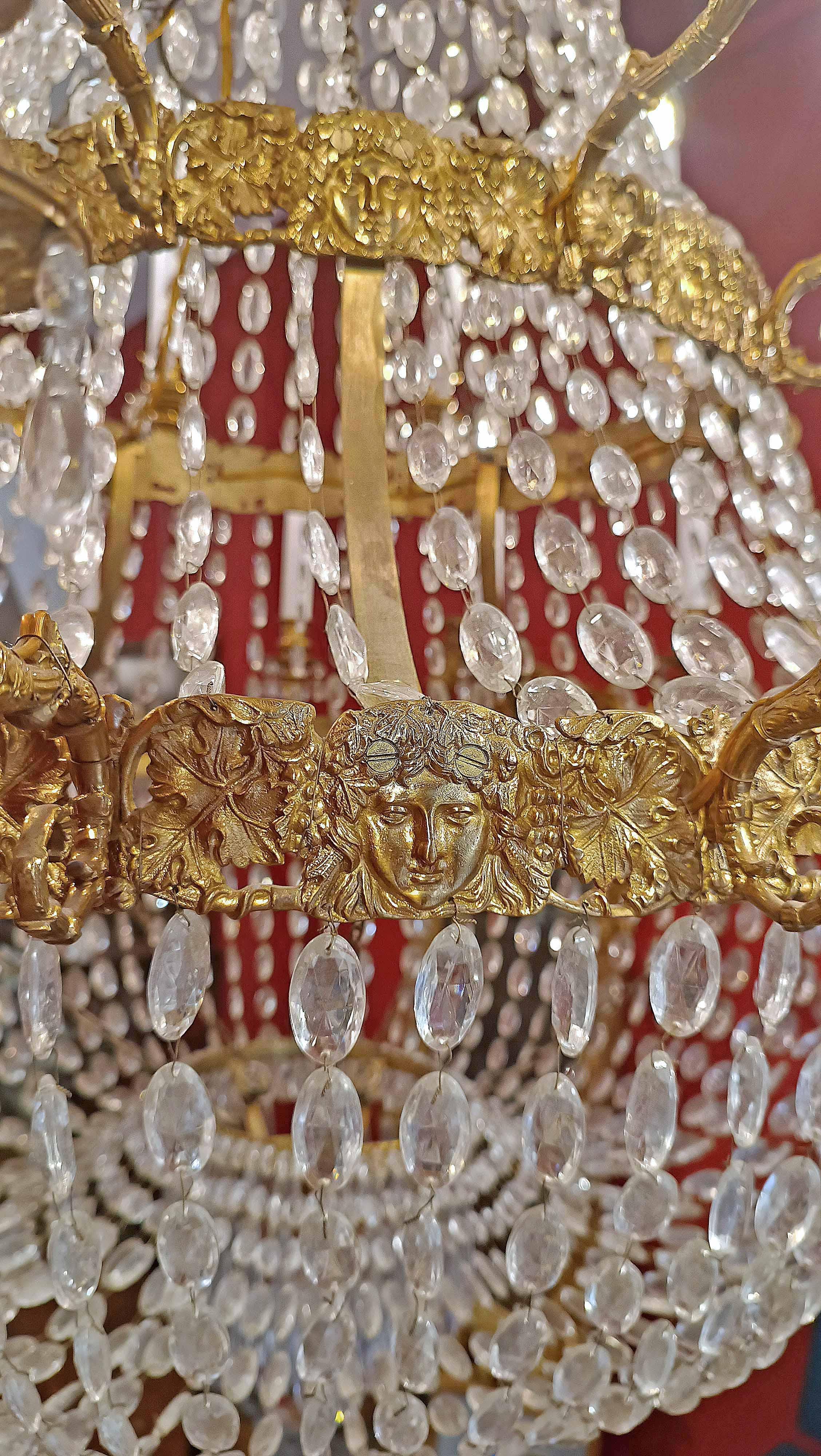 Beautiful large basket chandelier made of lost-wax gilded bronze, embellished with crystals. It features 24 lights, with arms shaped like a stylized cornucopia, also in gilded bronze, and small crystal pendants. The structure is divided by two