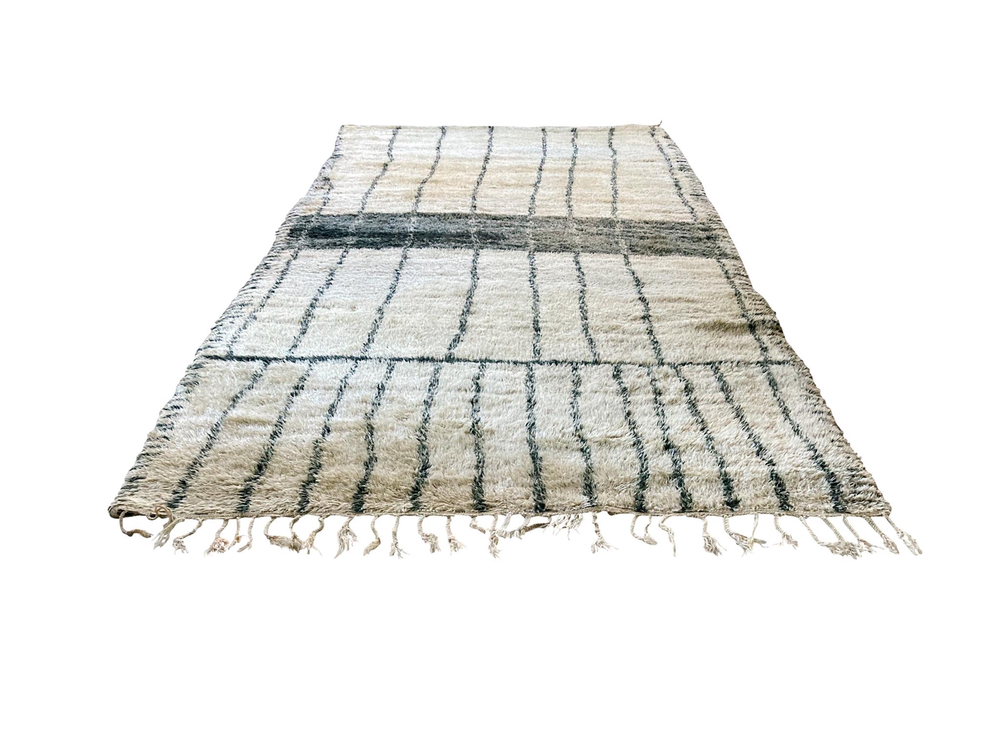 Ce grand tapis marocain Beni Ourain a été noué à la main au milieu du 20e siècle. Son design présente des rayures noires audacieuses qui s'étendent sur toute la longueur du tapis. Le tapis a été récemment nettoyé.

Dimensions :
6' 2