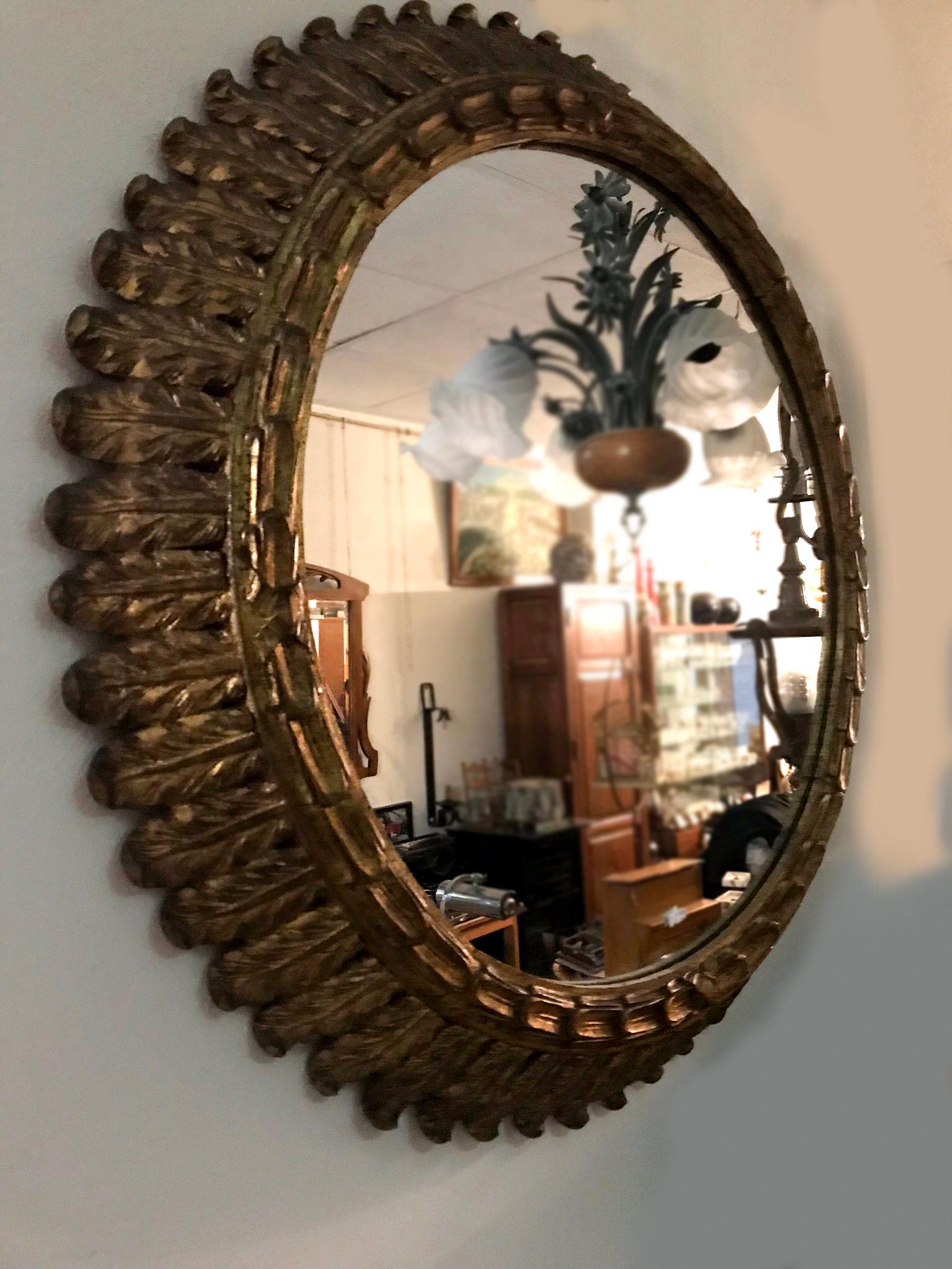 Large mid-20th century carved giltwood sunburst mirror.

Create a focal point in any room with this gleaming sun mirror. Hand carved, circa 1950, the large midcentury piece is decorated with intricate carvings throughout the foliage and has a