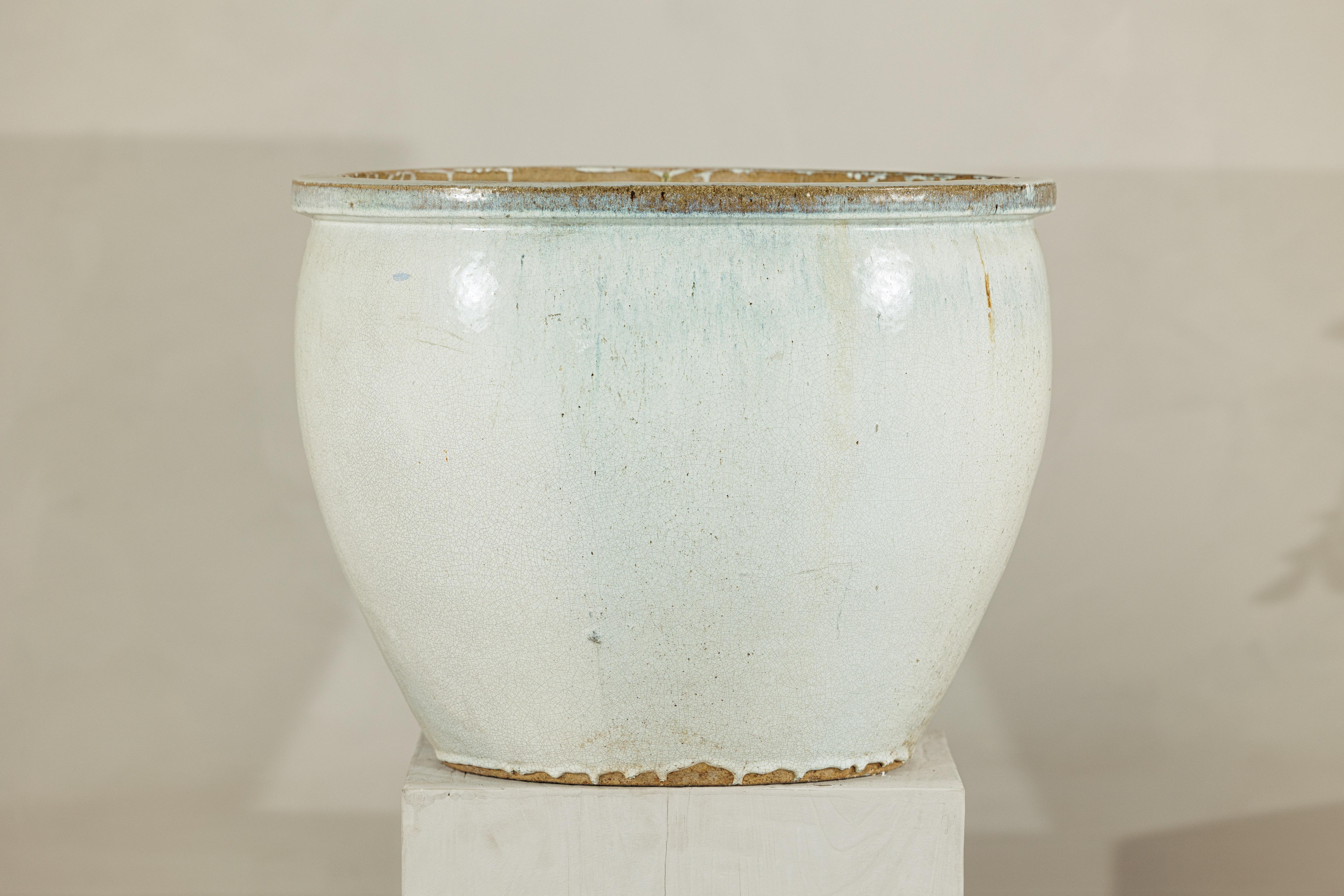 Ein großes chinesisches Pflanzgefäß aus Keramik im Vintage-Stil mit zarter weißer Craquelé-Glasur mit blassen Untertönen und subtilen Farbspritzern in der Nähe des Randes. Die großzügige runde Form, der dicke Rand und der leicht ausgestellte Sockel