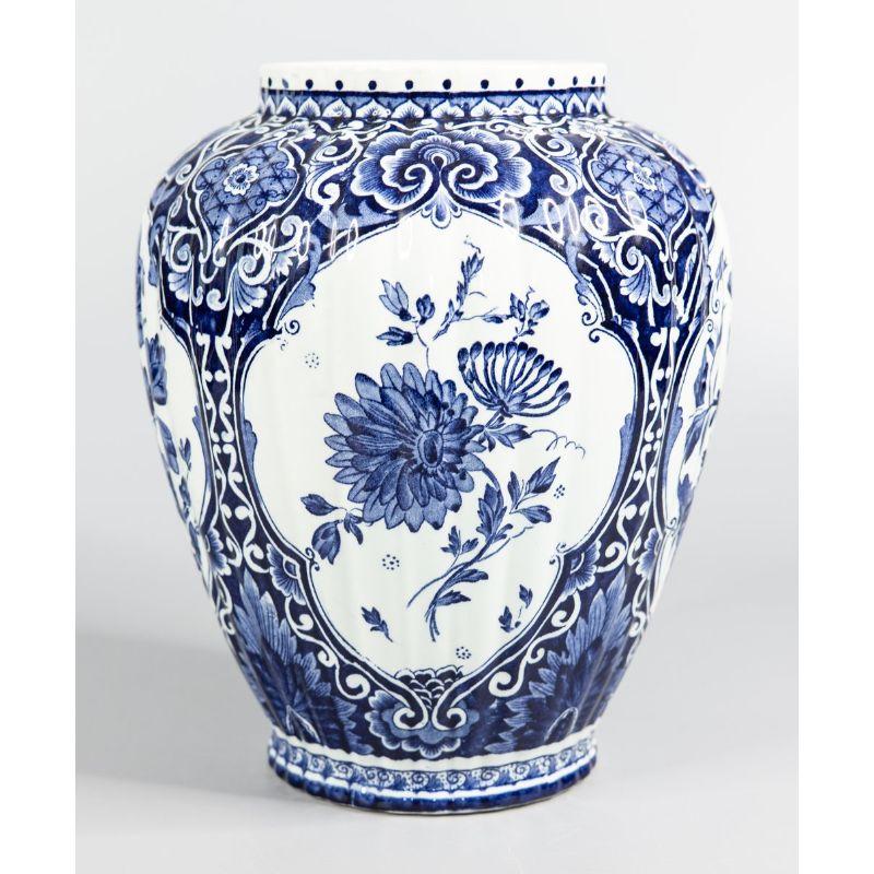 A lovely Mid-Century Dutch Delft faience vase by well known Dutch maker, Petrus Regout Maastricht. Maker's mark on the reverse. This stunning vase is a nice large size with a wonderful ribbed shape and a vibrant blue and white floral motif. It would