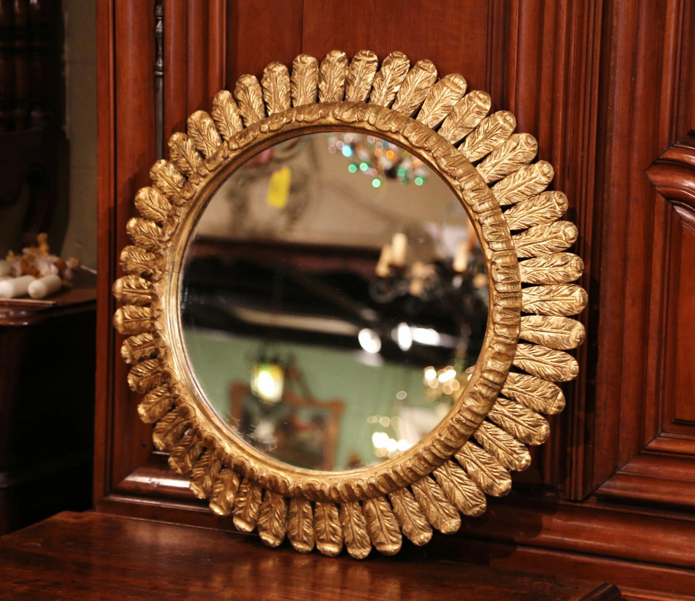 Create a focal point in any room with this gleaming, sun mirror from France. Hand carved circa 1940, the large, mid-century piece is decorated with intricate foliage carvings throughout, and has a shape and shimmering texture that resembles the glow