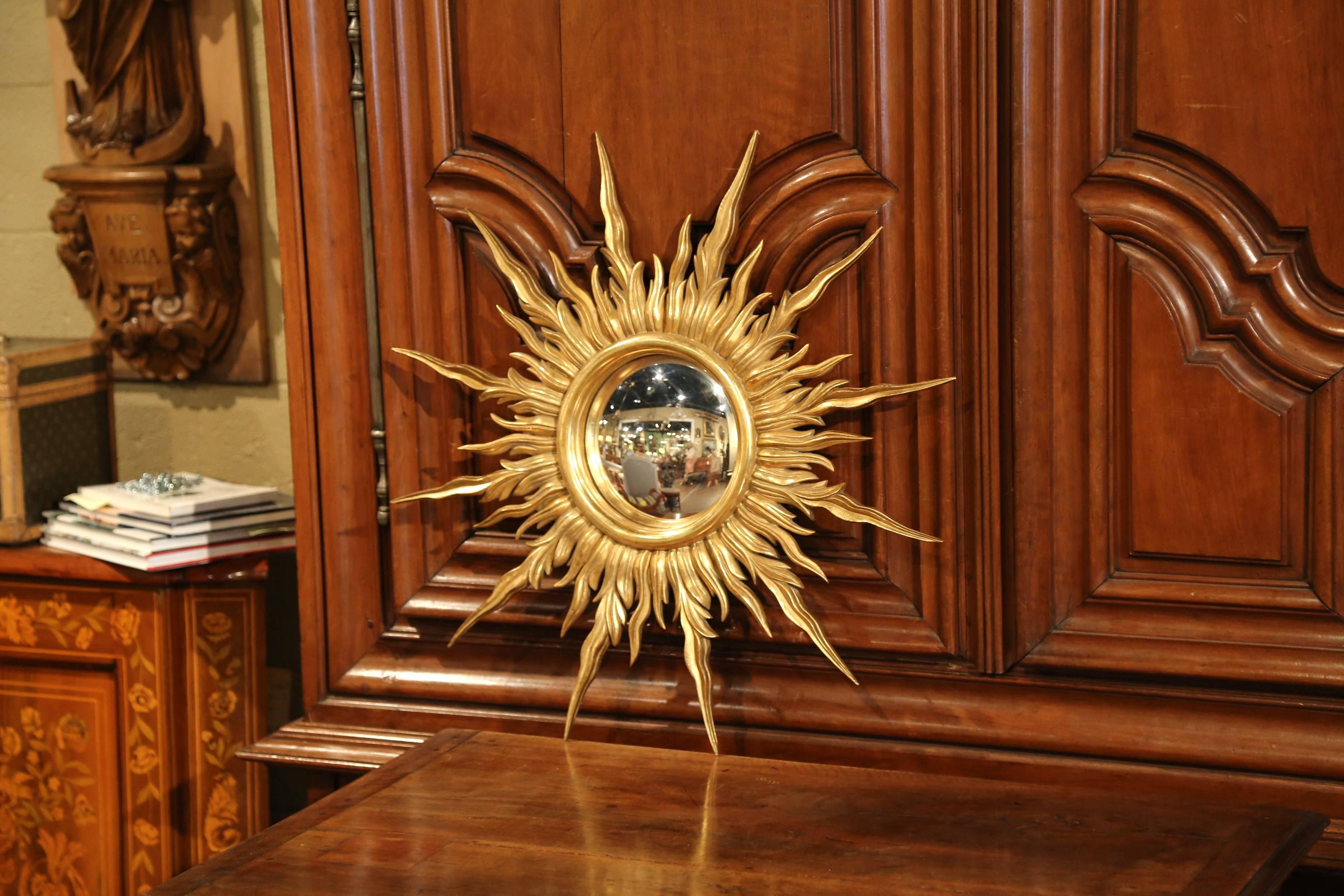 Add a beautiful shine to your home with this eye-catching sun mirror from Versailles, France. Made circa 1960, this mirror has a Classic sunbeam shape, a round convex glass in the center, and a rich rubbed gold leaf finish. In excellent condition,