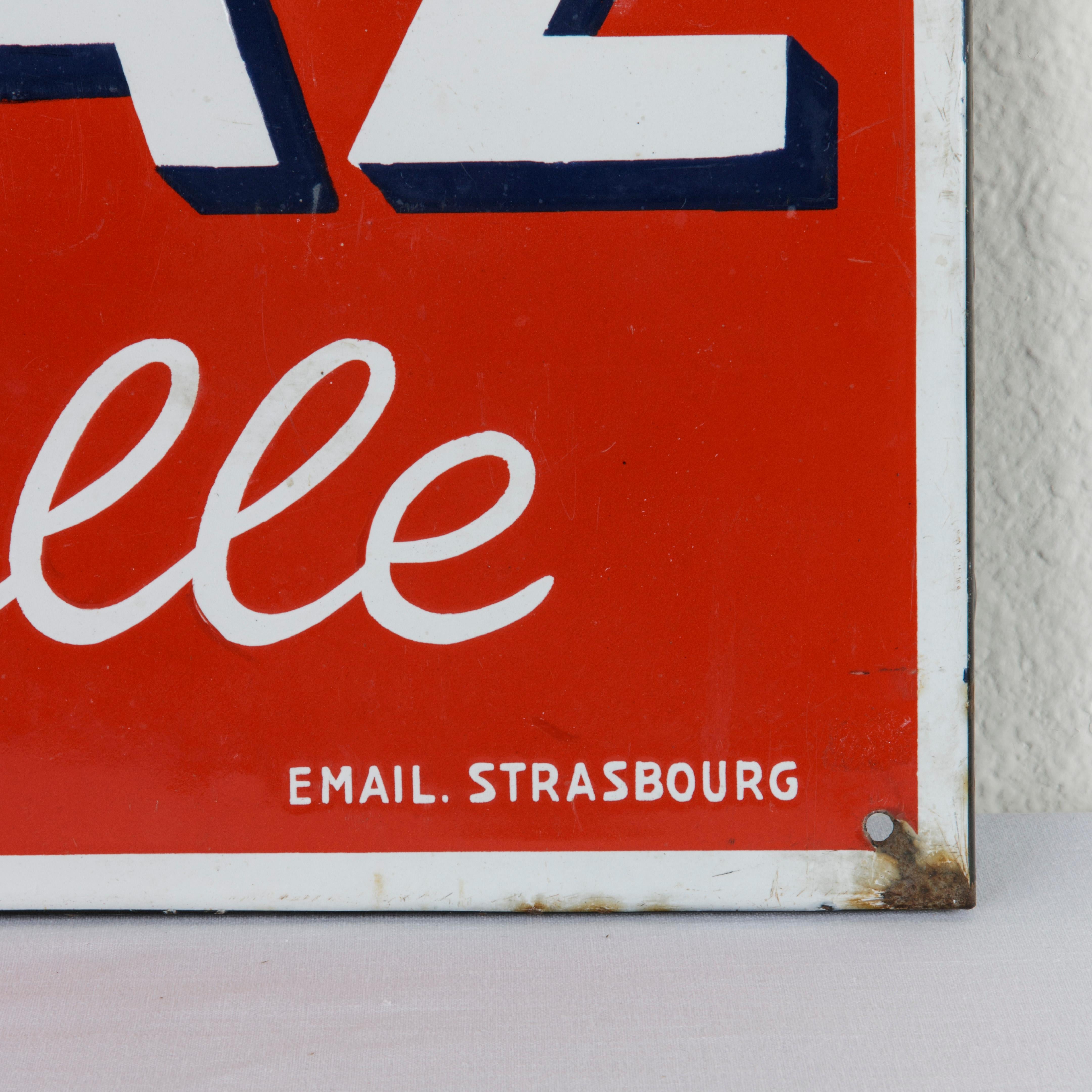 Measuring 14.5 inches high and 38 inches long, this large French enameled metal sign advertises Primagaz, gaz en bouteille or in English, Propane, gas in a bottle. Marked email Strasbourg (enamel from Strasbourg, France) and En vente ici (Sold