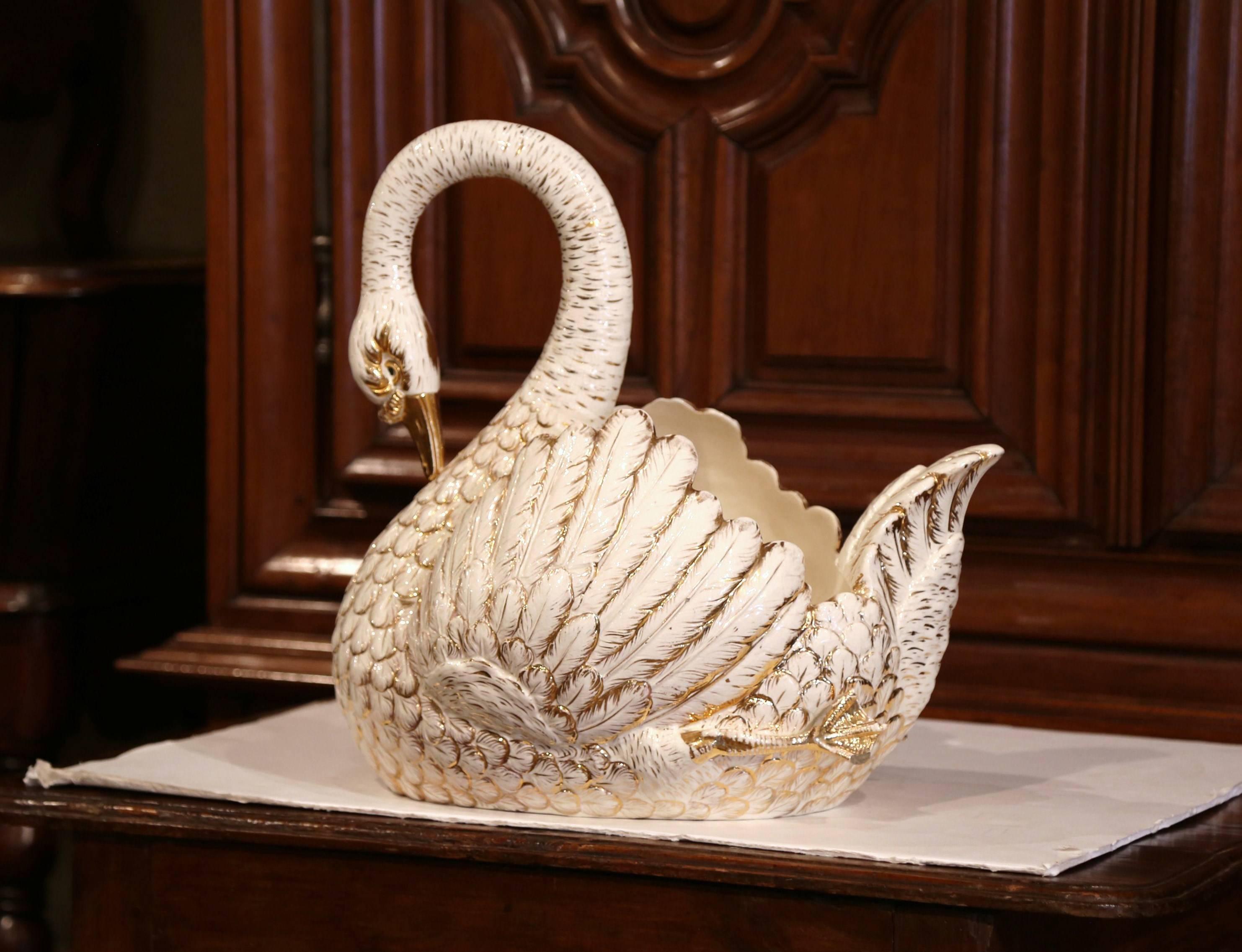 This large faience sculpture was crafted in France, circa 1960. Shaped as a swan picking its neck, the vintage bird centre piece has a deep and wide body, with wings and feet carved on the sides. This sculptural piece could be used for holding fruit