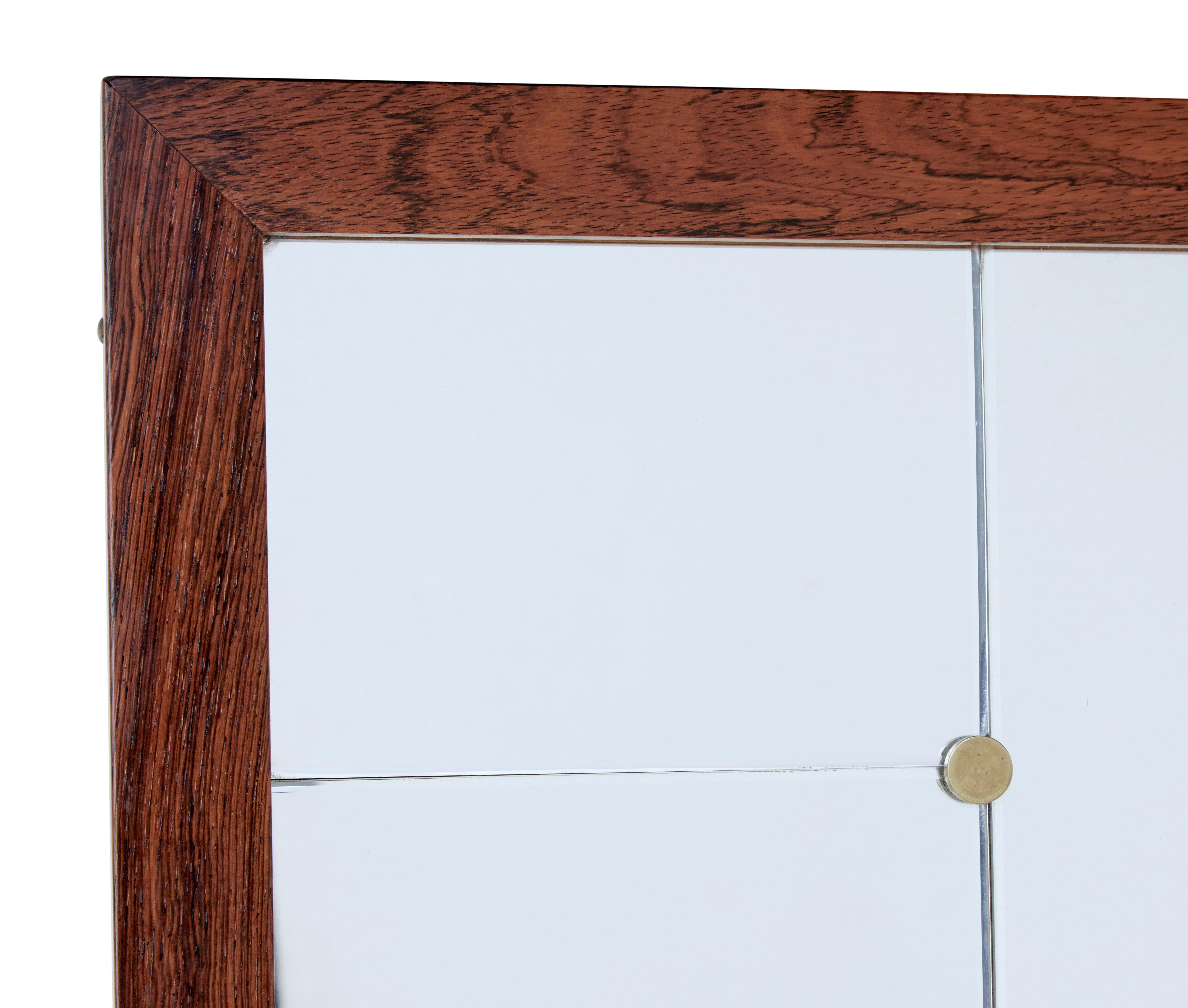 Large mid-20th century palisander wall mirror by Glas and Tra circa 1950.

Large and heavy wall mirror in the Art Deco style by well known Swedish makers Glas and Tra. Palisander veneered frame. Central portrait mirror flanked either side by