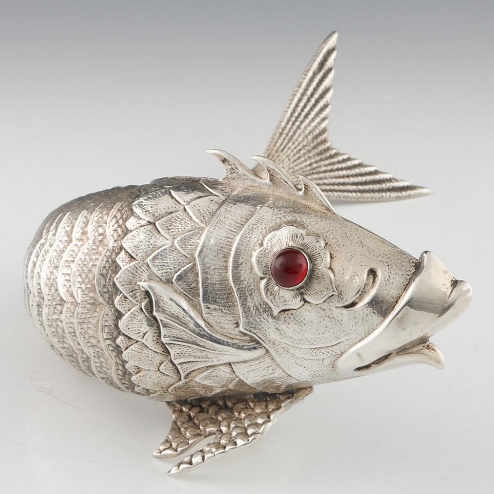 Heading : Mid 20th century Spanish silver articulated fish sculpture
Date : Mid 20th century
Period : Franco
Origin : Madrid, Spain
Decoration : In the formm of a fish, the articulated scales allowing for flexibility in the body of the fish. Ruby