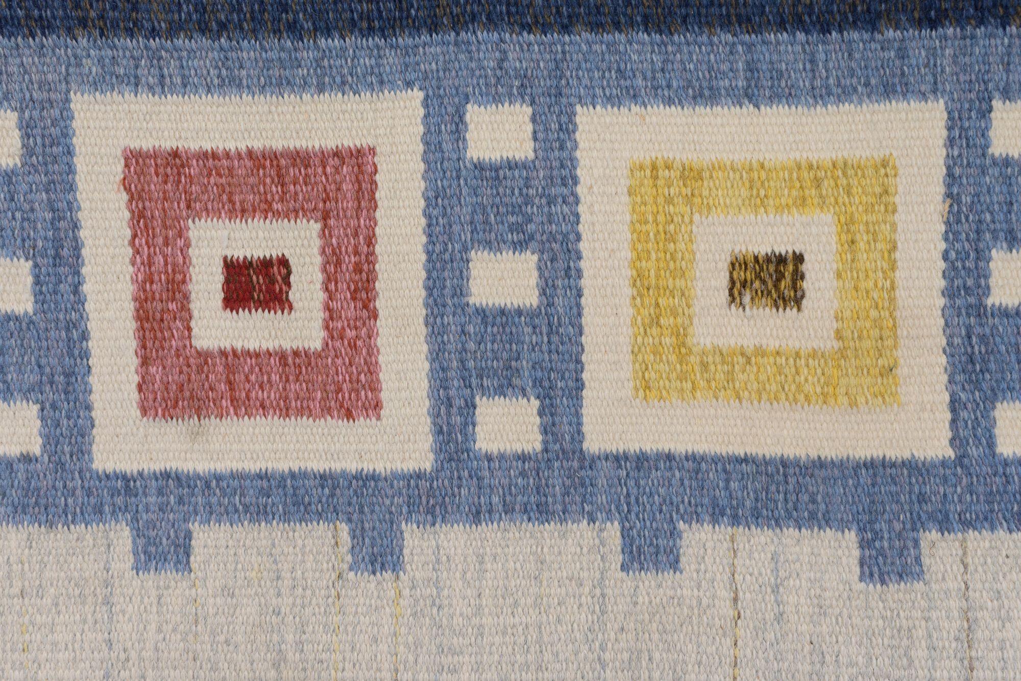 Grande kilim svedese di metà secolo nei toni del blu e del crema, con un insolito motivo a bordi quadrati colorati. Firmato.
Svezia, circa 1960.
H. 169 cm x L. 240 cm x P. 1 cm