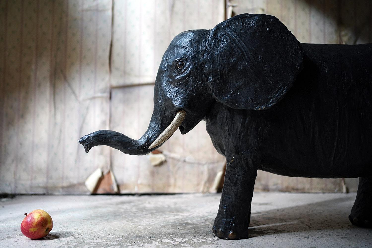 The most likely unique and most certainly charming large hand painted model of a stylised elephant at almost three feet long, with a nodding weighted head, the whole black painted with brown highlighted feet and ivory painted tusks, and with wooden