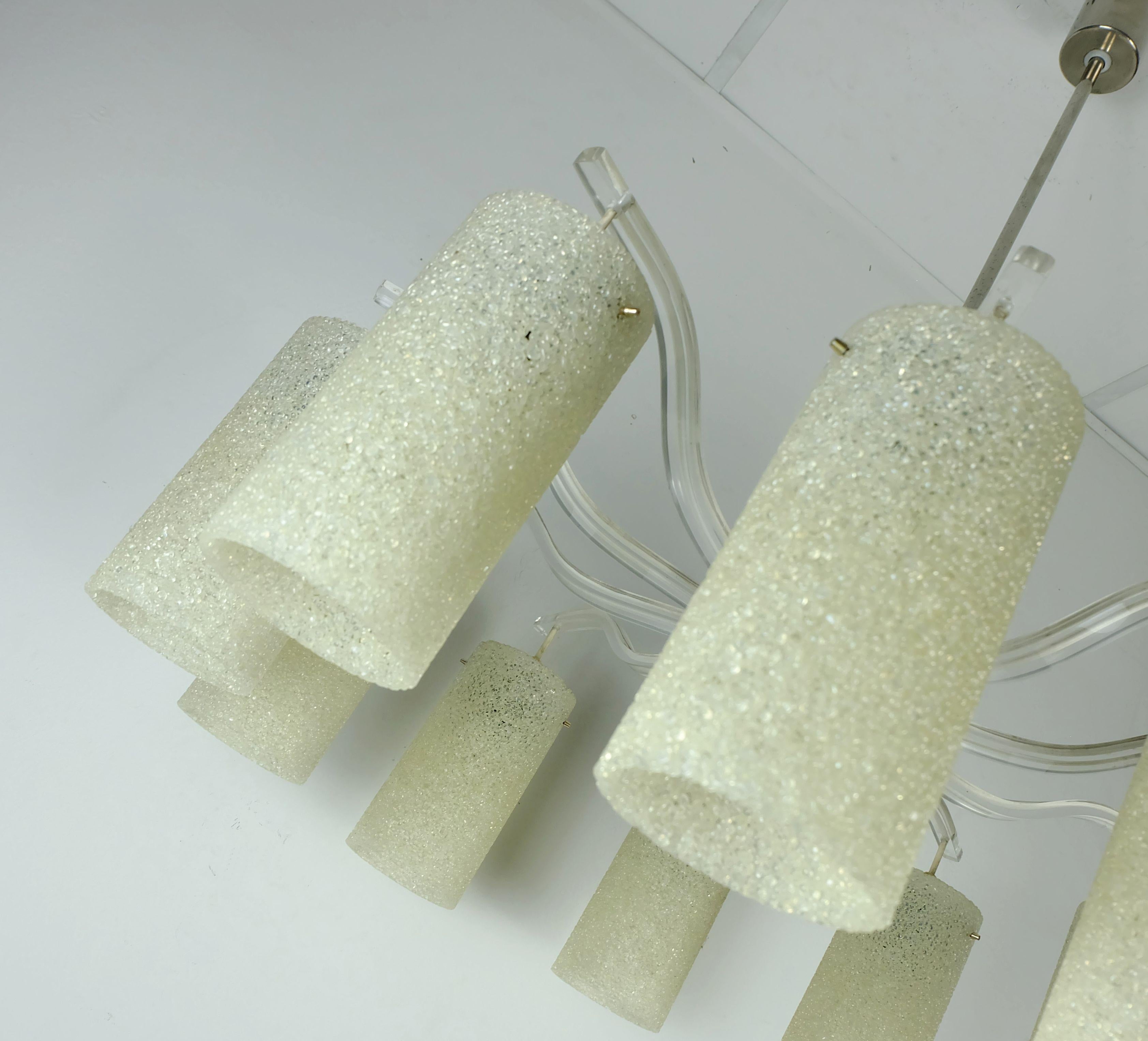 Remarquable lustre des années 50 et 60 du milieu du siècle. Bras incurvés en plexi translucide, abat-jour en forme de tube en granulés de plastique beige. Centre en bakélite couleur ambre, tige et baldaquin en métal nickelé. Peut contenir des