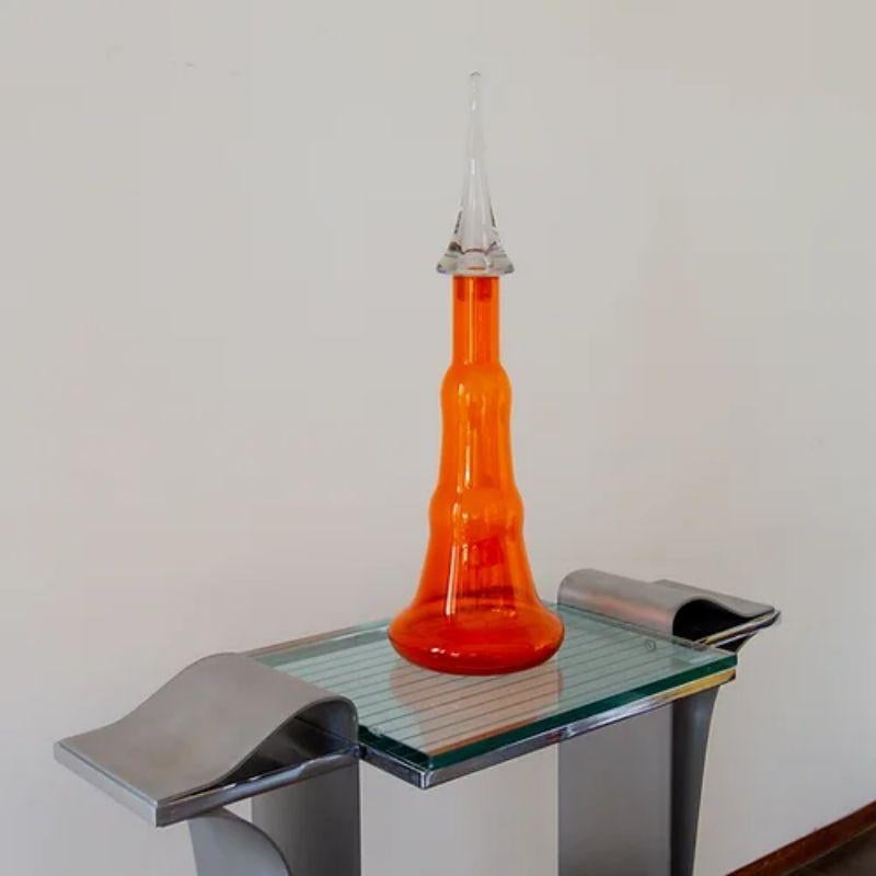 A large tangerine glass decanter with a large clear moulded stopper by mid 20th century American company, Viking est.1944-1970

Additional Information:
Material: Glass
Dimensions: 68.5 H cm.