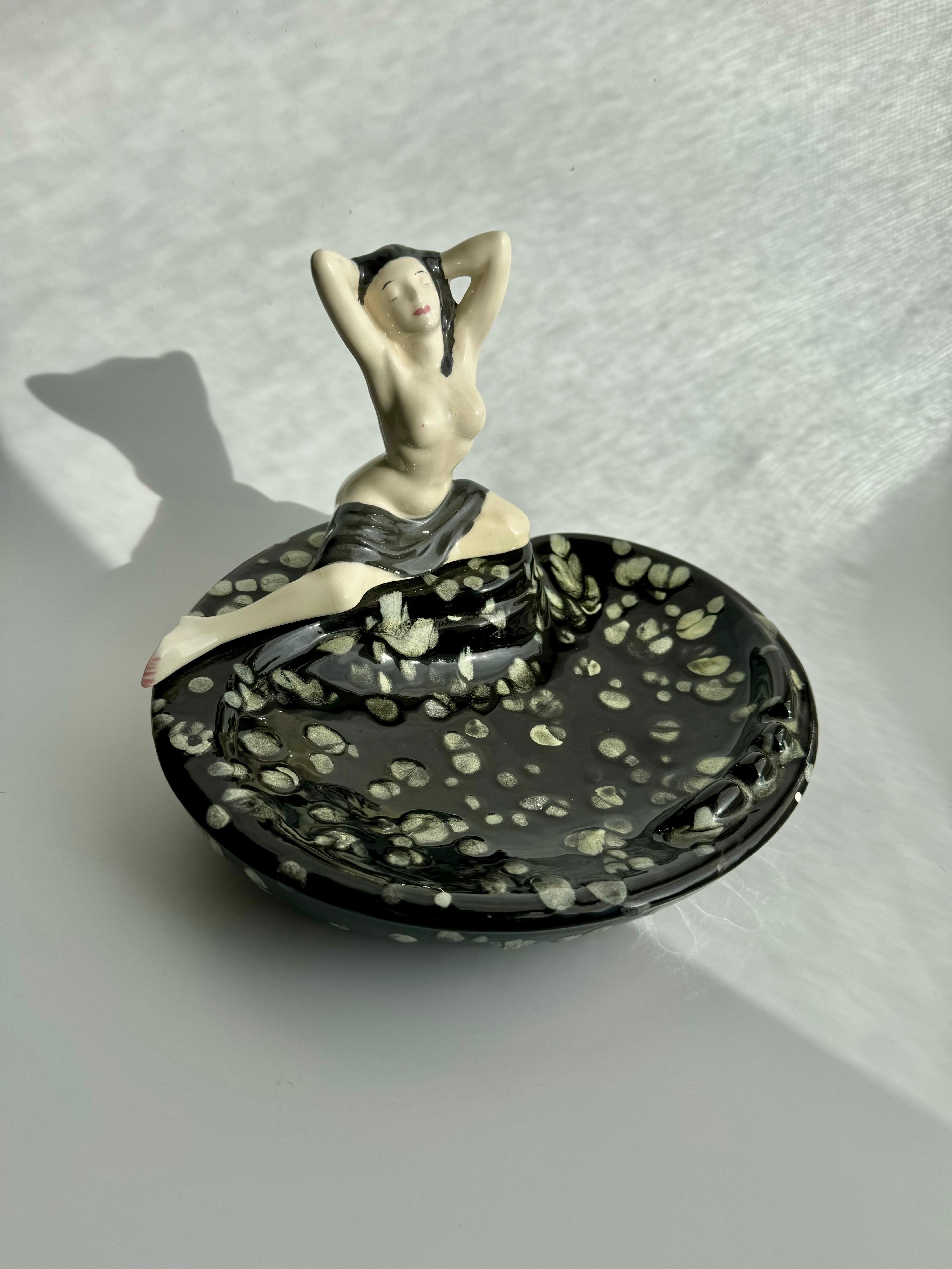 Atemberaubender Aschenbecher aus der Mitte des Jahrhunderts mit dem nackten weiblichen Körper einer jungen Frau, die auf dem Rand der Schale sitzt. Dieses prächtige Stück ist sehr künstlerisch und könnte auf viele Arten verwendet werden, als
