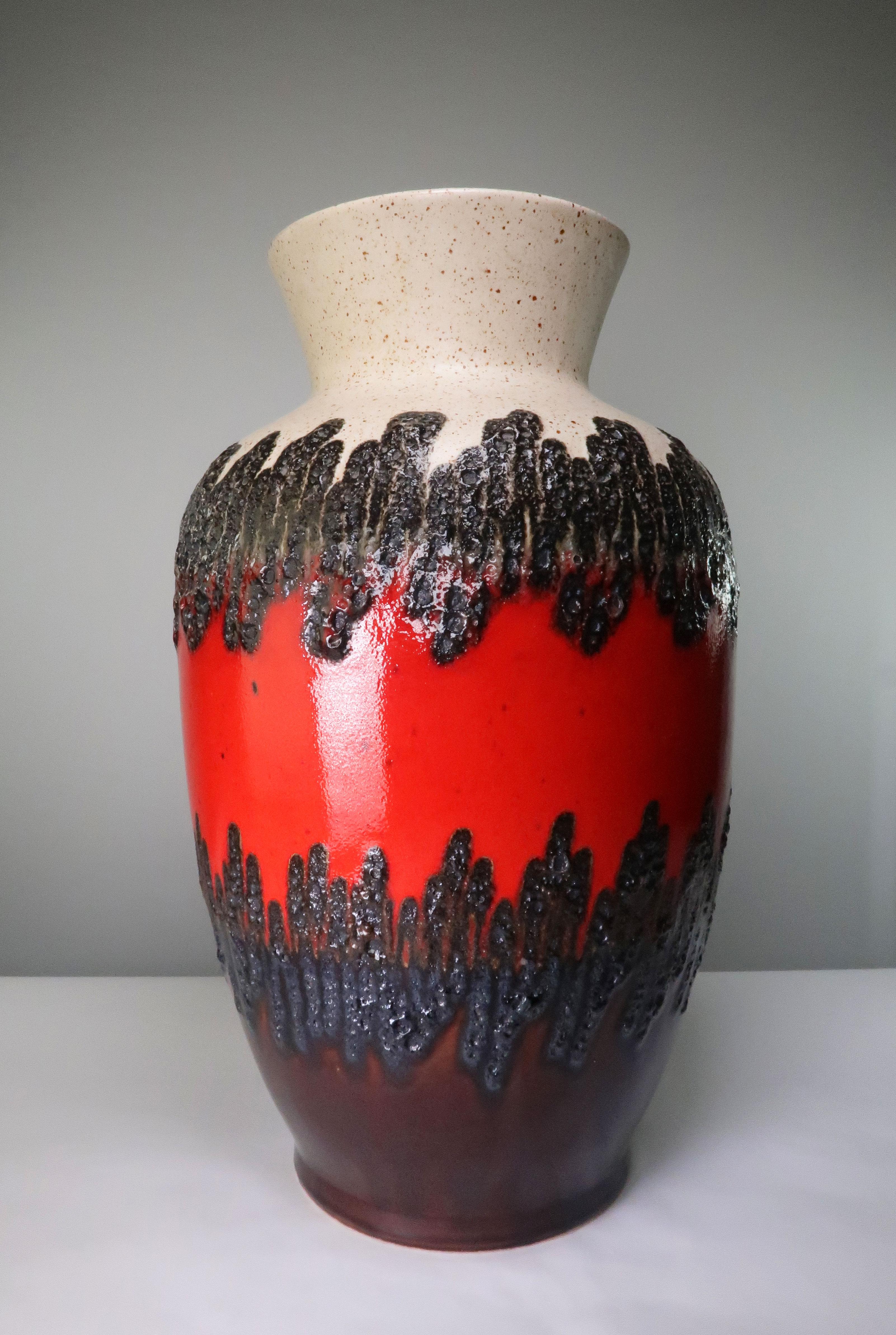 Large Mid-Century Modern floor vase by German ceramics manufacturer Bay Keramik in the 1960s. Shiny and smooth blood red glaze on the belly with black lava glaze on the top and black and dark blue lava glaze underneath. Beige top and interior and