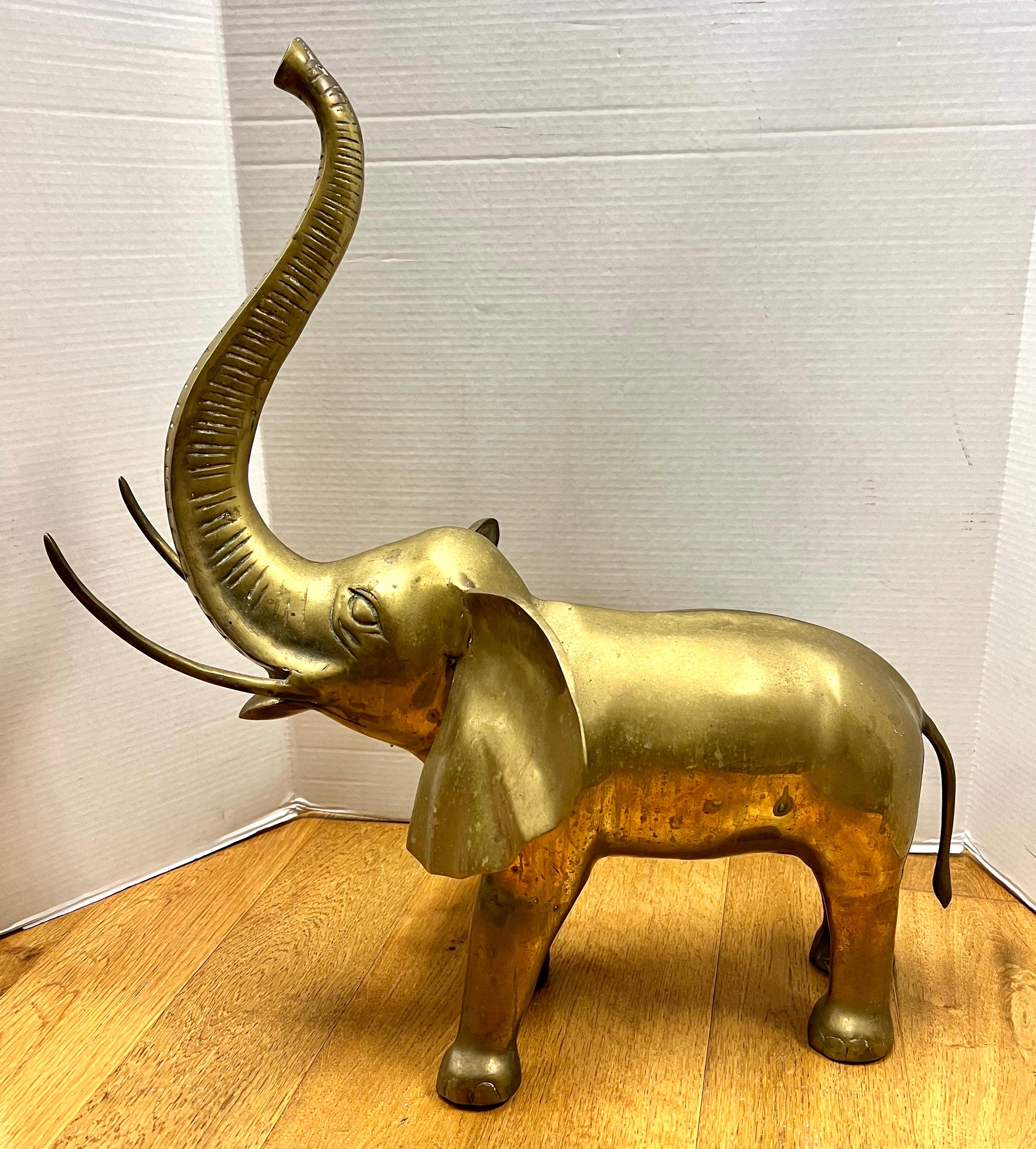 Large vintage heavy brass elephant statue stands with its trunk up which is said to bring good fortune, money, and goodwill.