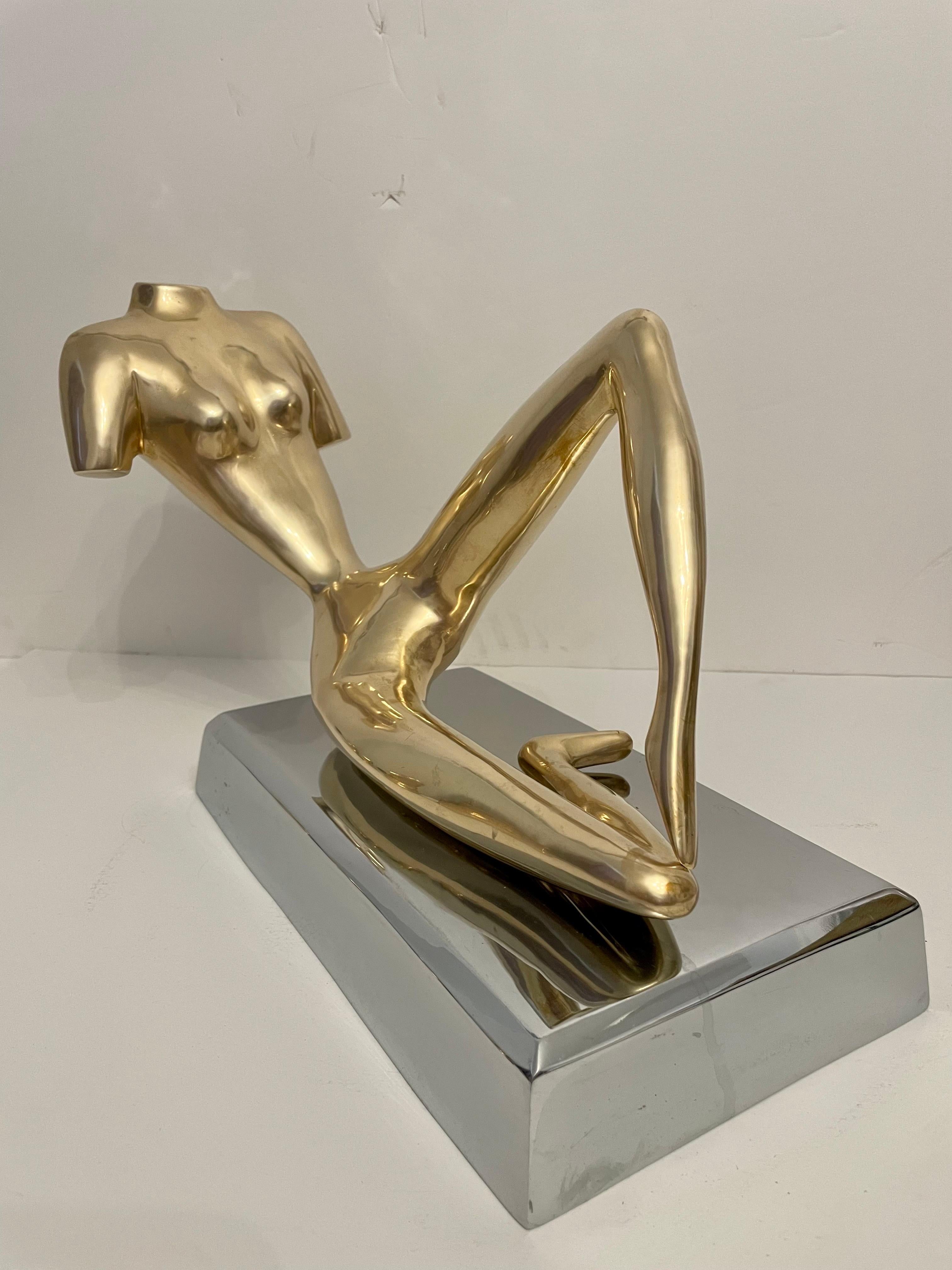 A very good quality decorative midcentury large reclining nude brass figural sculpture on cast, thick, beveled aluminum base, inspired by the iconic style of renowned sculptor Jean Hans Arp (1886 - 1966). This captivating piece seamlessly blends