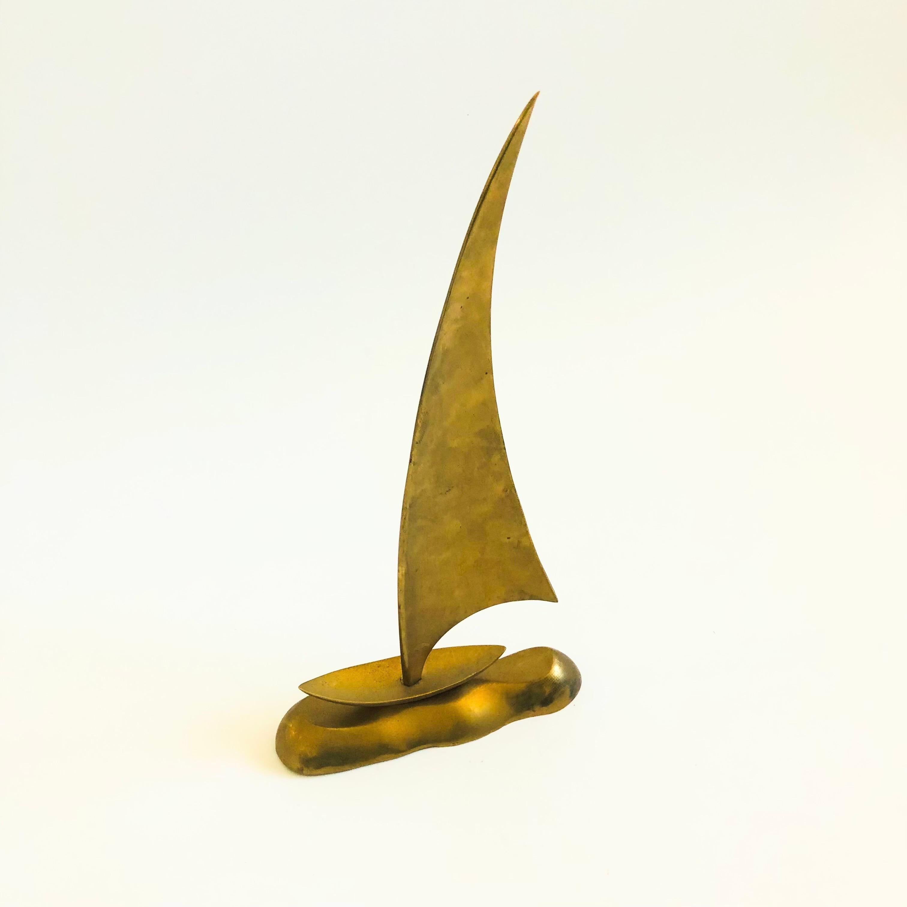 A large mid century brass sailboat.

