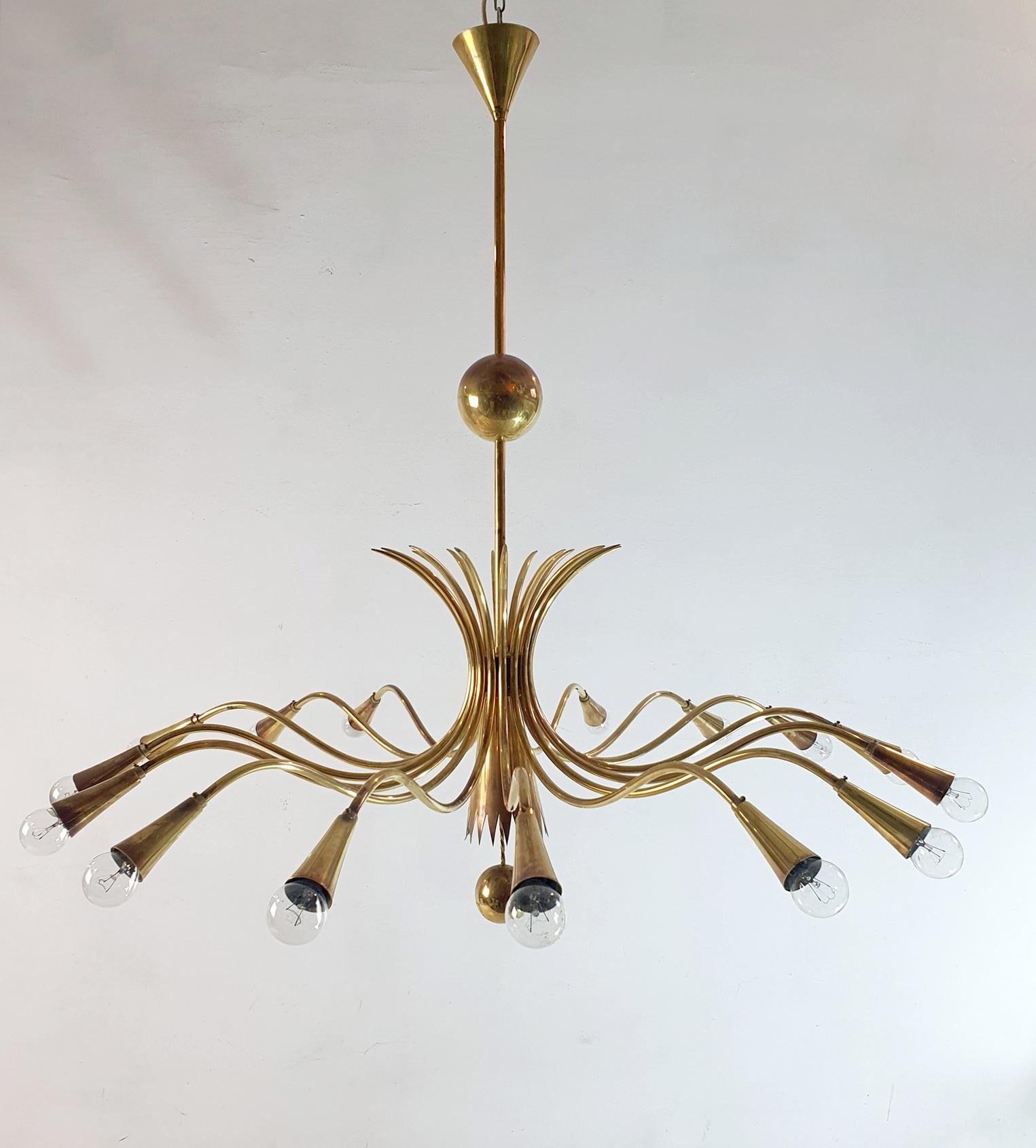 Rare and large mid-century chandelier in brass with sixteen arms in the manner of Guglielmo Ulrich, Italy. Fully functioning and in original condition. Electricity is fully functioning. This elegant chandelier is handmade during the 1950's and