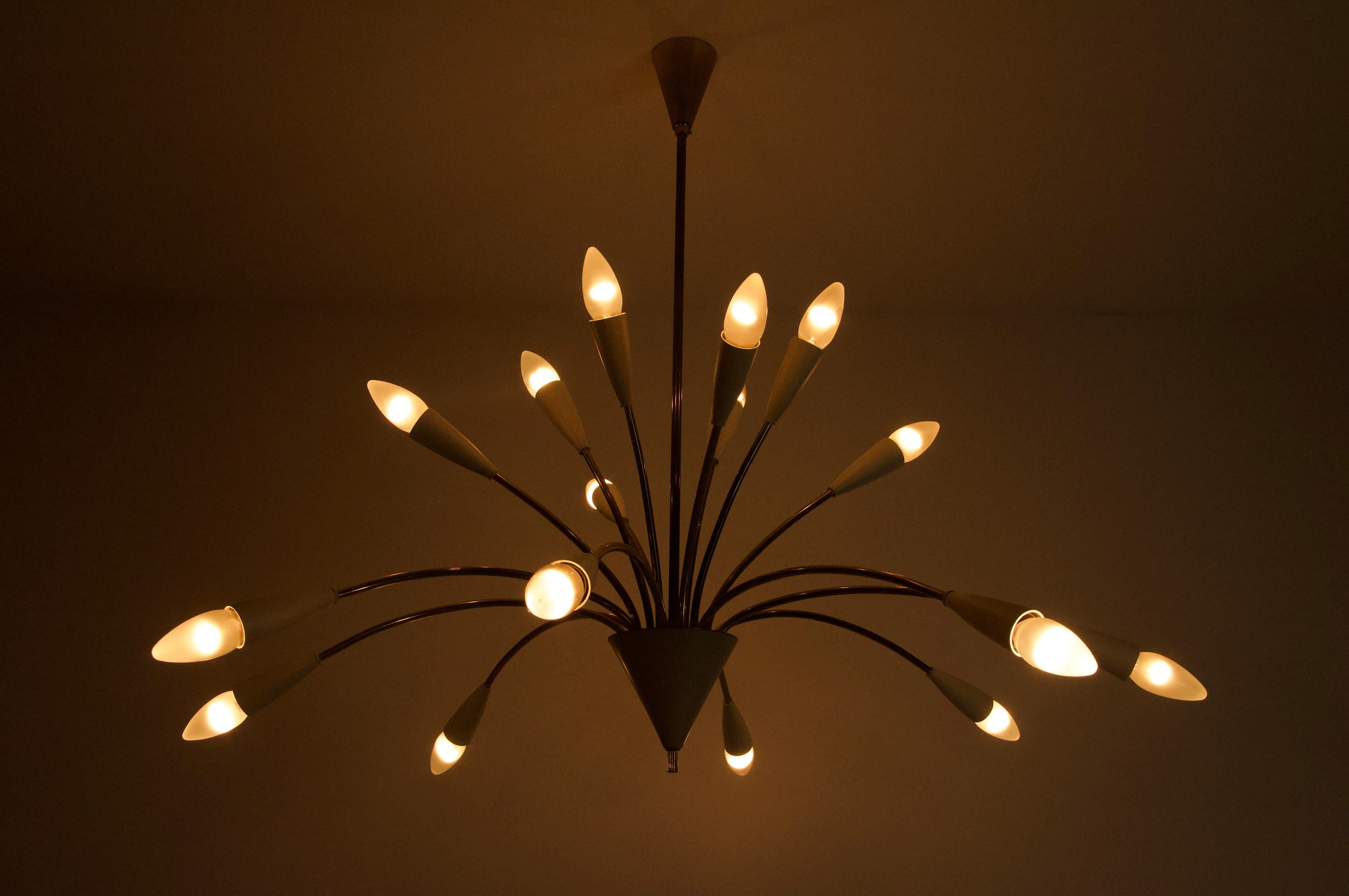 This breathtaking Sputnik chandelier from the 1960s embodies the elegance and visionary spirit of mid-century design. Crafted in Germany, it features a dynamic, starburst silhouette with gracefully curved brass arms extending outward in perfect