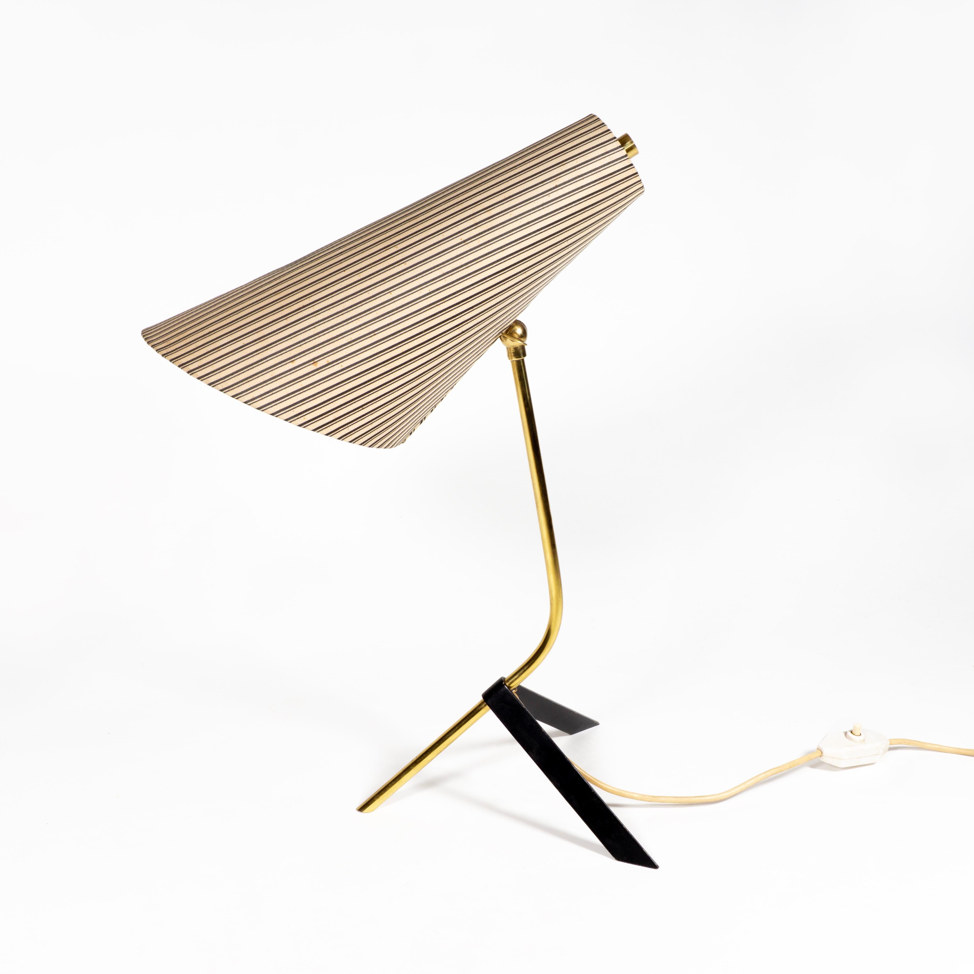 L'elegante lampada da tavolo in ottone e metallo è dotata di un paralume affusolato in tessuto a righe (che può essere regolato in diverse posizioni a seconda delle esigenze) e ancora dell'originale e pratico interruttore on/off.
Questa lampada