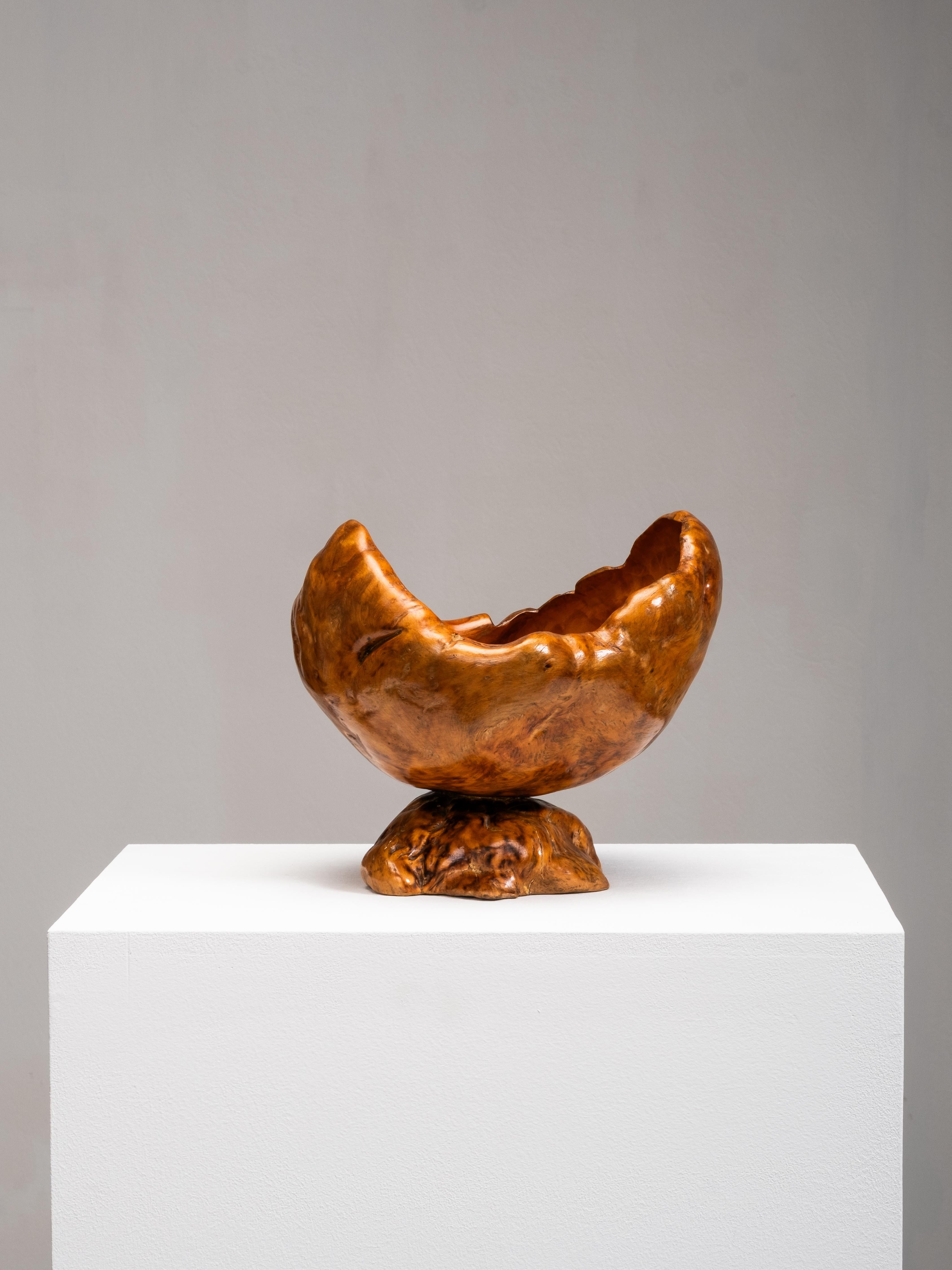 Una grande ciotola vintage intagliata a mano, realizzata in Finlandia nel 1954. Realizzato in legno di radica, il pezzo presenta una forma organica e audace con una superficie liscia e lucida che mette in risalto le venature vorticose e le calde