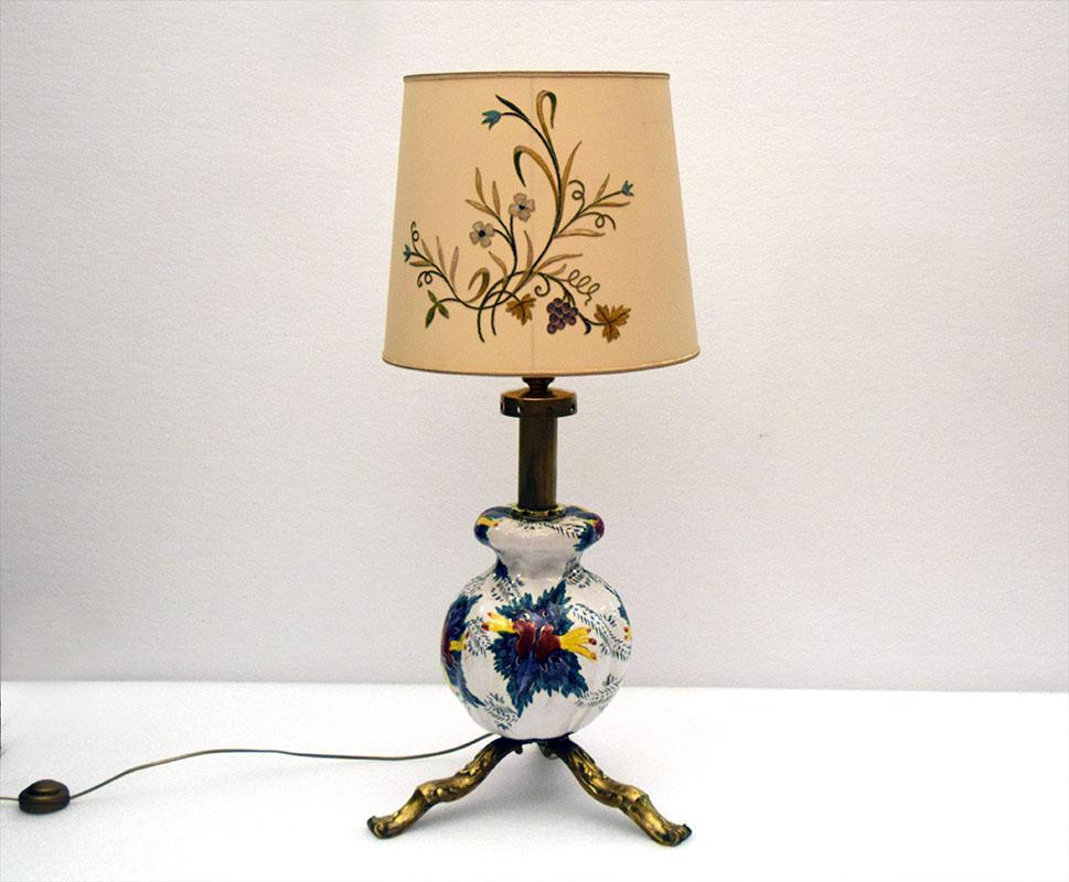 Large ceramic and brass lamp, mid-century Italian production, 1950s.
Three-legged base and lamp holder in brass, ceramic body hand-decorated by with floral motif and original vintage lampshade hand-embroidered with floral decoration.
In excellent