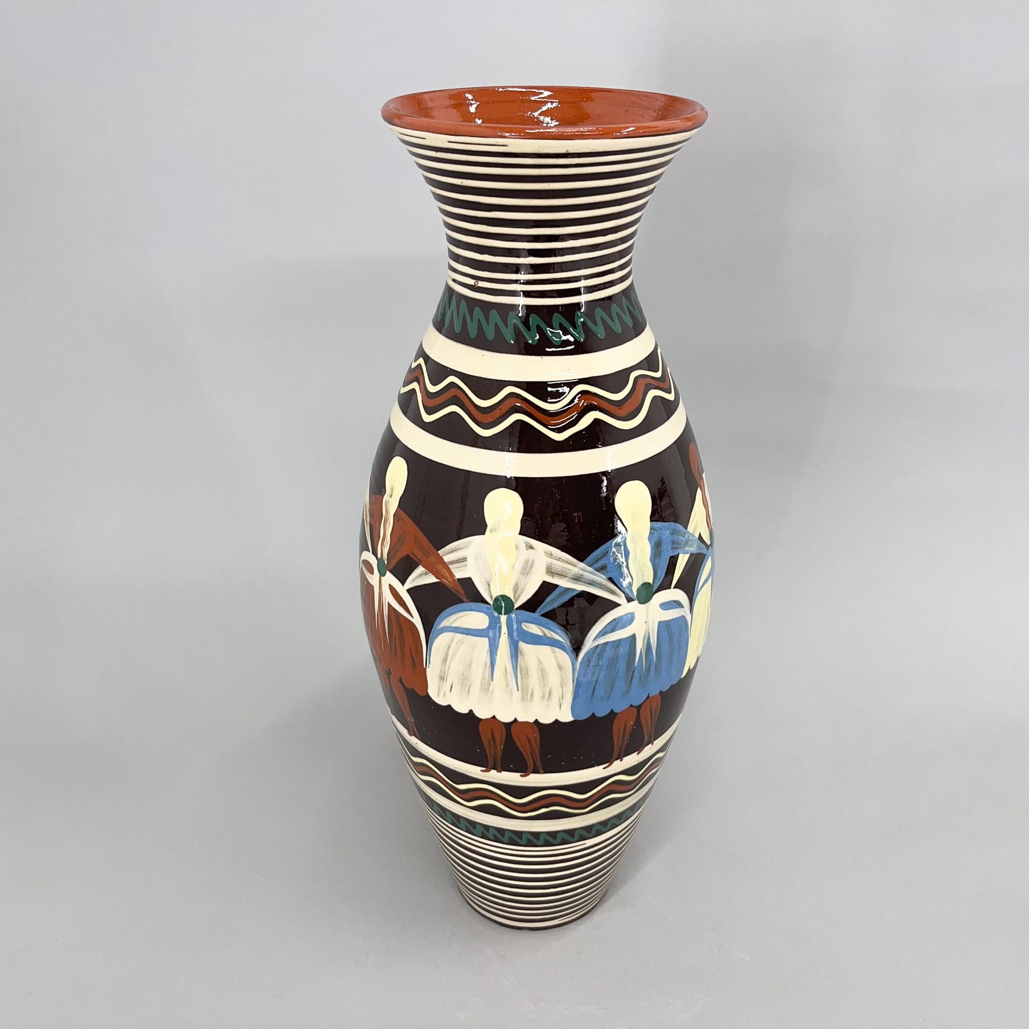 Vintage vase or floor vase made of glazed ceramics with motif of dancing women in typical national costumes.