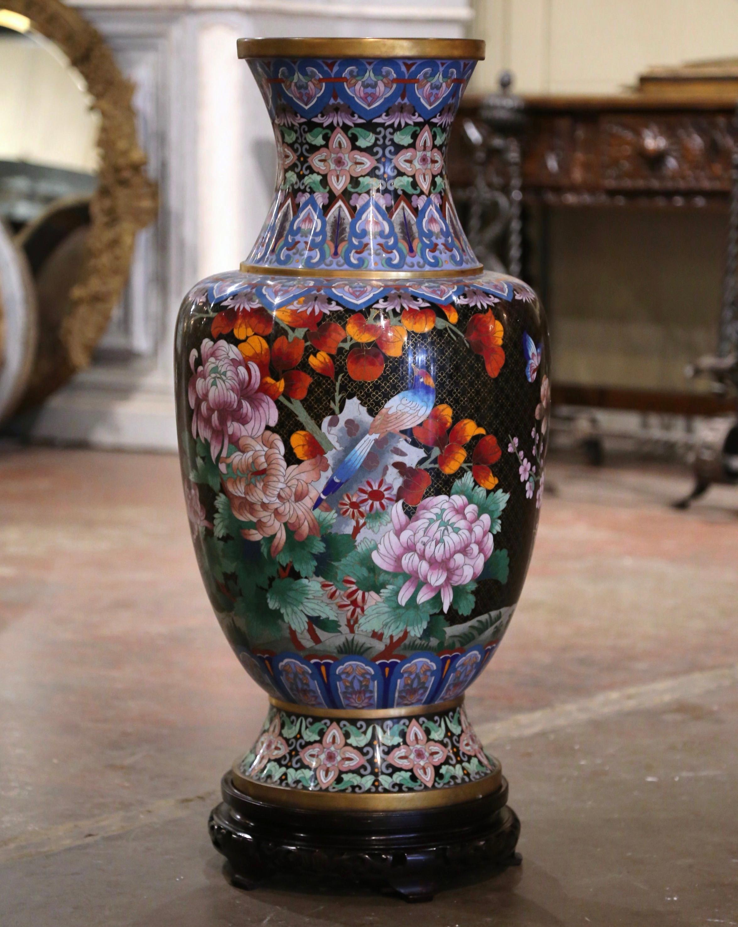 Decorate a buffet or console with this important cloisonne vase. Created in China circa 1960, and almost three feet tall, the large vase sits on a carved ebonized wood stand and features a black-ground with qua-trefoil pattern fretwork, stylized