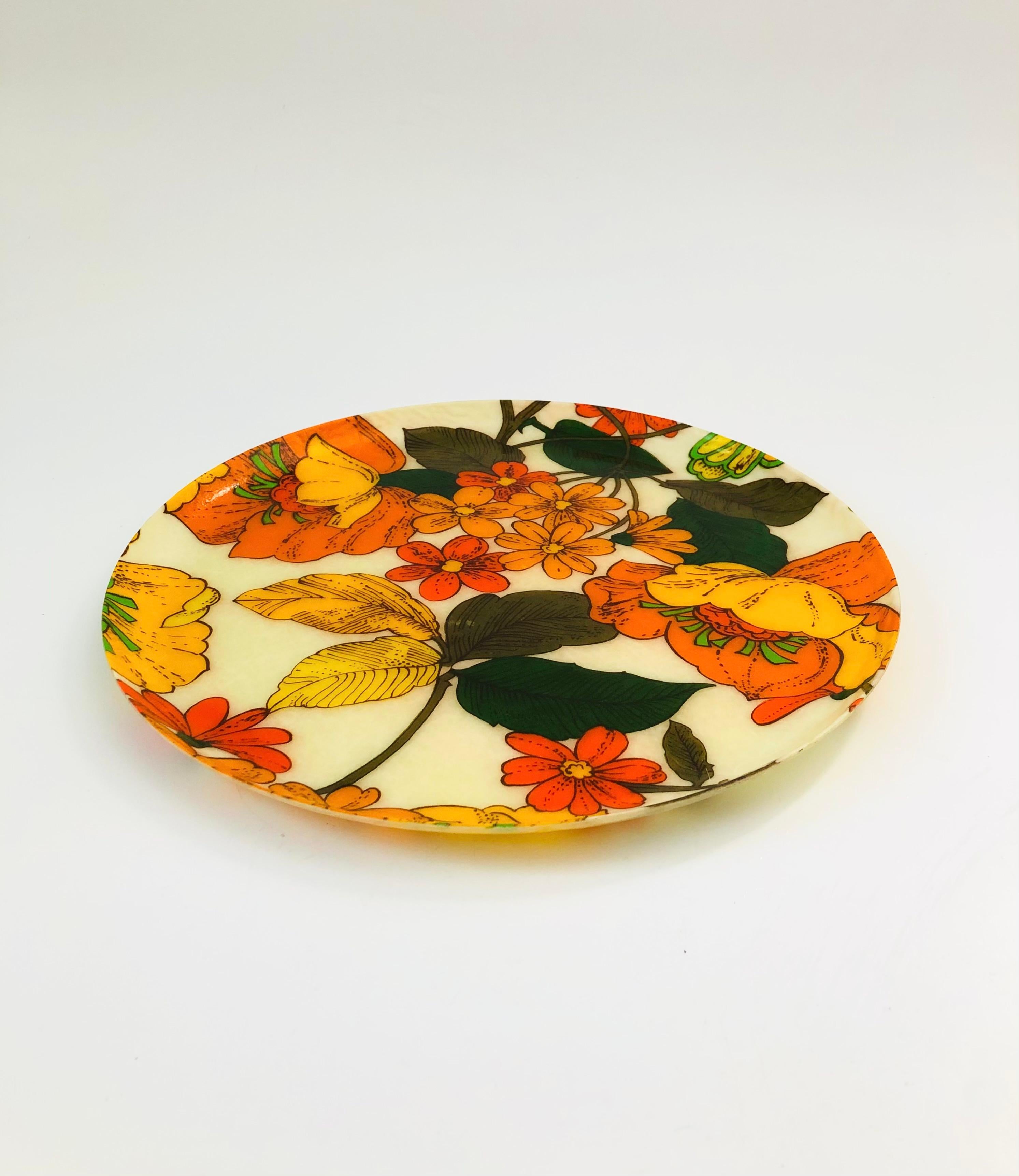 A large circular mid century tray with a bold floral design. Made out of fiberglass.
    