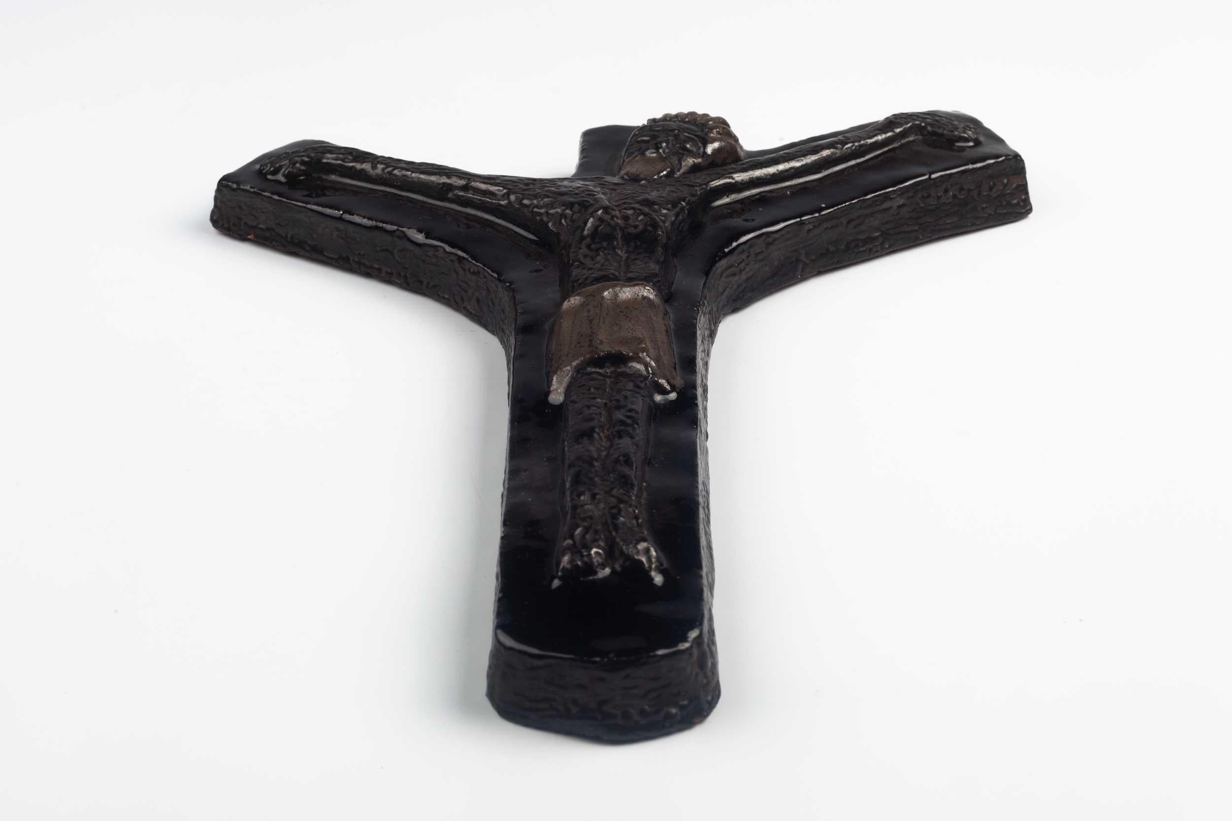 Large glossy brown ceramic wall cross, handmade in Europe in the 1960s. Asymmetrical cross shape with a figurative and textured Christ figure. A one-of-a-kind, handcrafted piece that is part of a large collection of crosses made by Belgian artisan