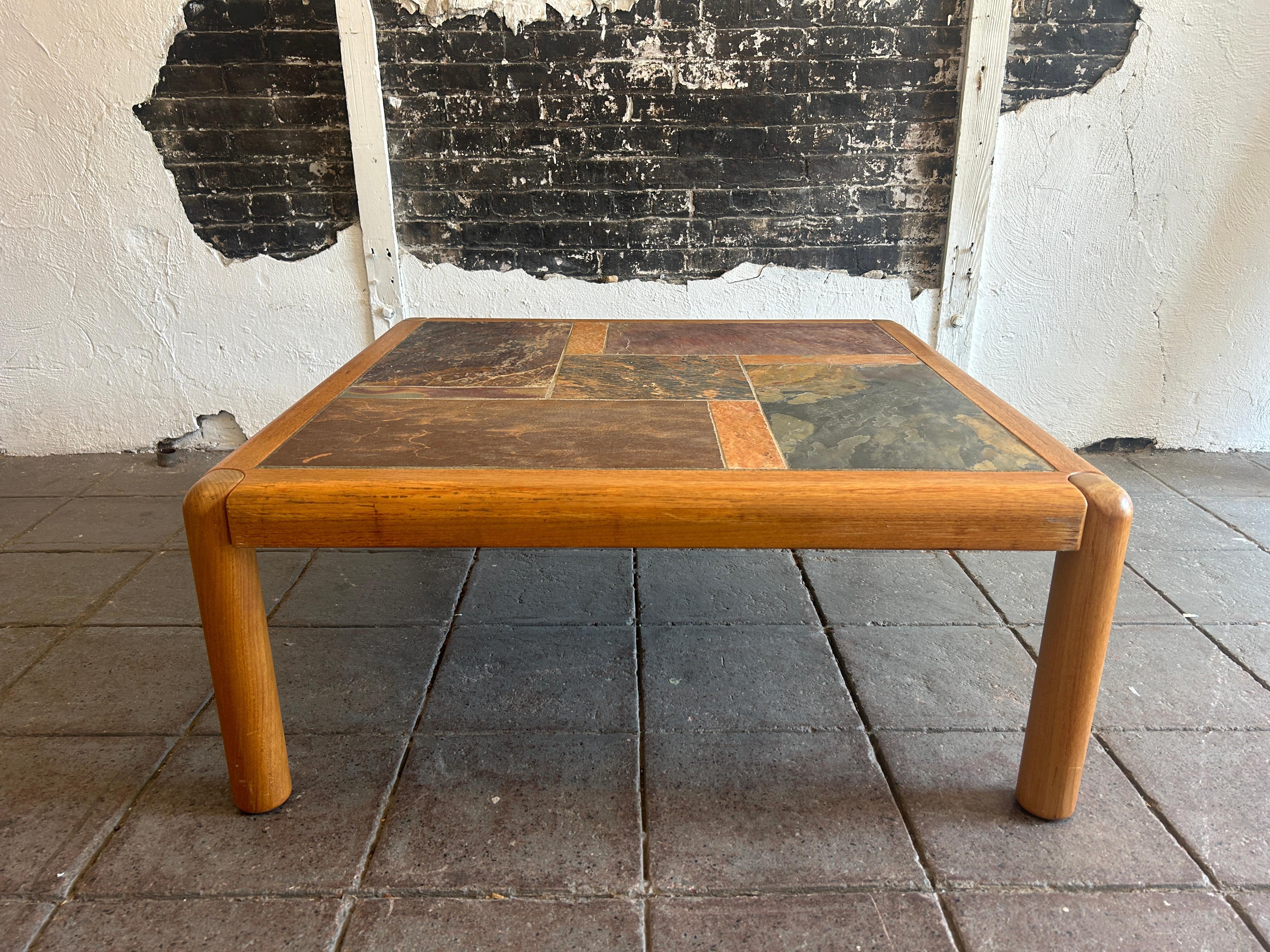 Large Mid century Danish modern teak 42” square light teak coffee table with slate top - with large round solid teak Legs. Very clean all around beautiful muted natural slate color tiles. Beautiful unique coffee table. Labeled made in Denmark.
