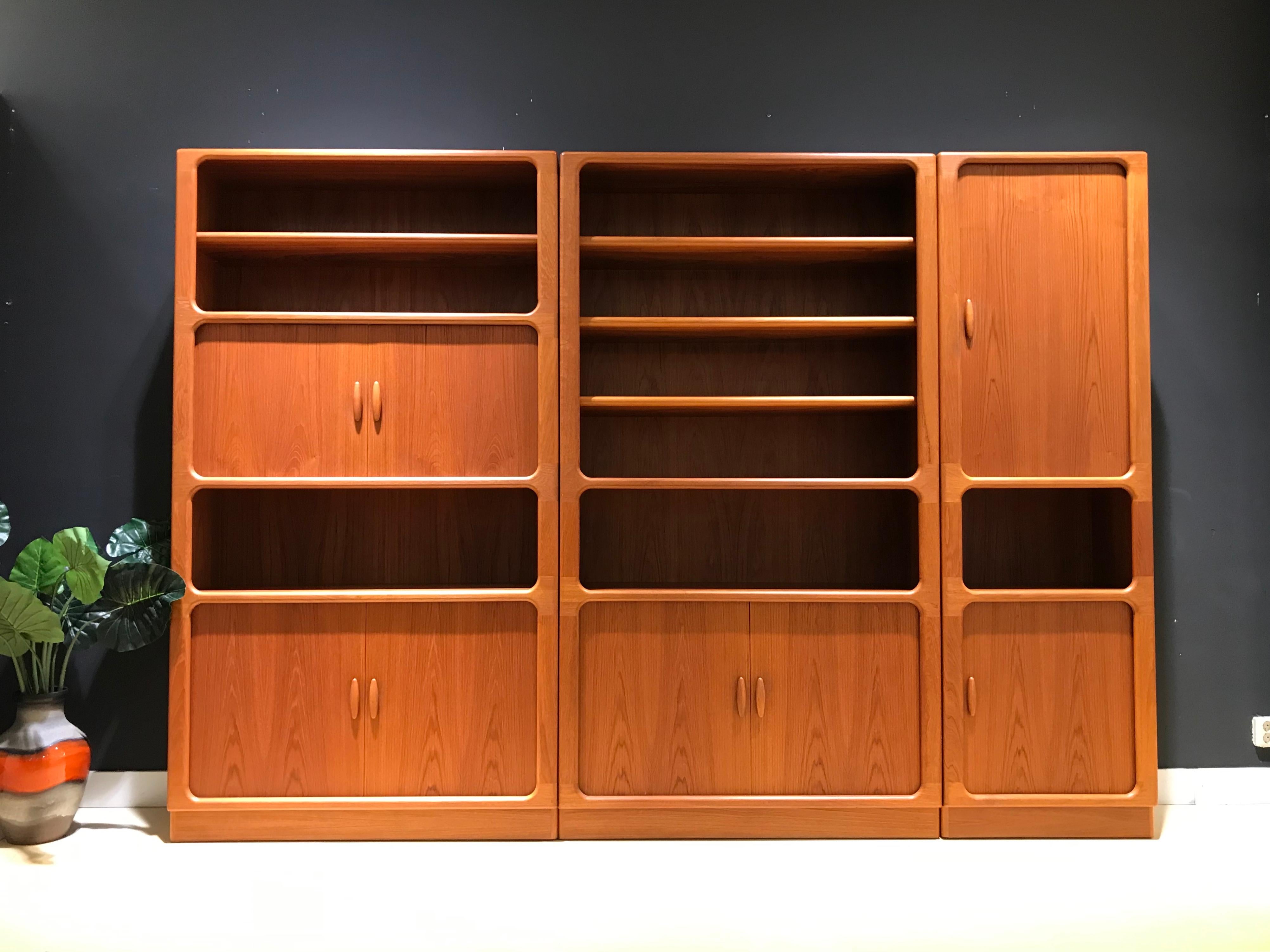 This stunning teak wall unit is made in the 1970s by Dyrlund with only Danish cabinetmaking techniques and hand finishing. Dyrlund's midcentury furniture is prized for its exceptional craftmanship and timeless, Minimalist aesthetic, but also for