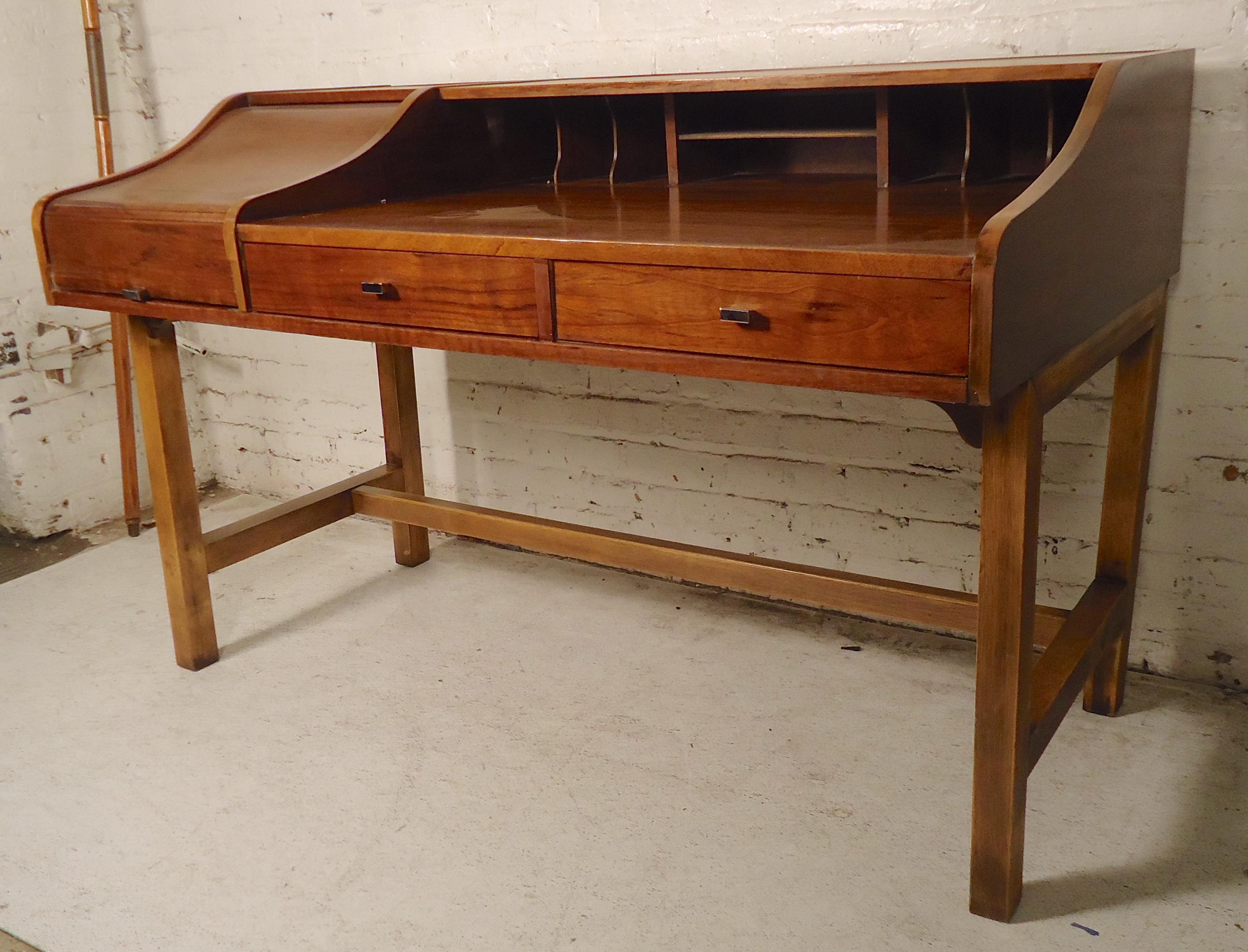 Vintage modern writing desk by Lane Furniture in walnut. Roll top side compartment, two drawers, wide writing surface with cubbies.
(Please confirm item location - NY or NJ - with dealer).
  